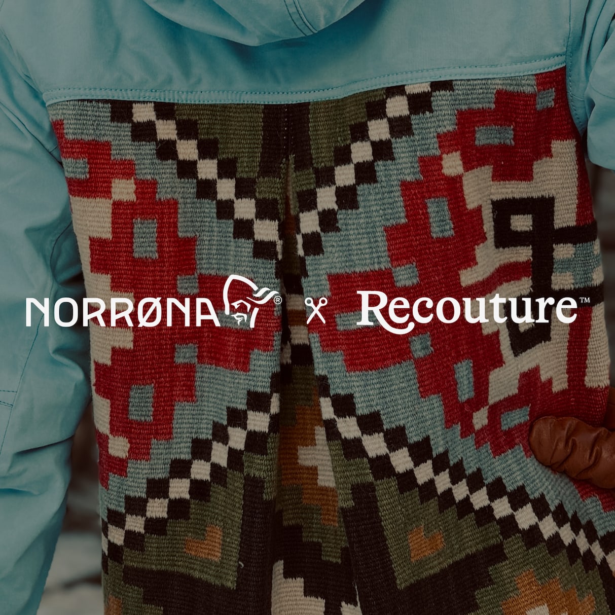 Person wearing a light blue Norrøna jacket with a patterned back. The jacket is a collaboration with Recouture.
