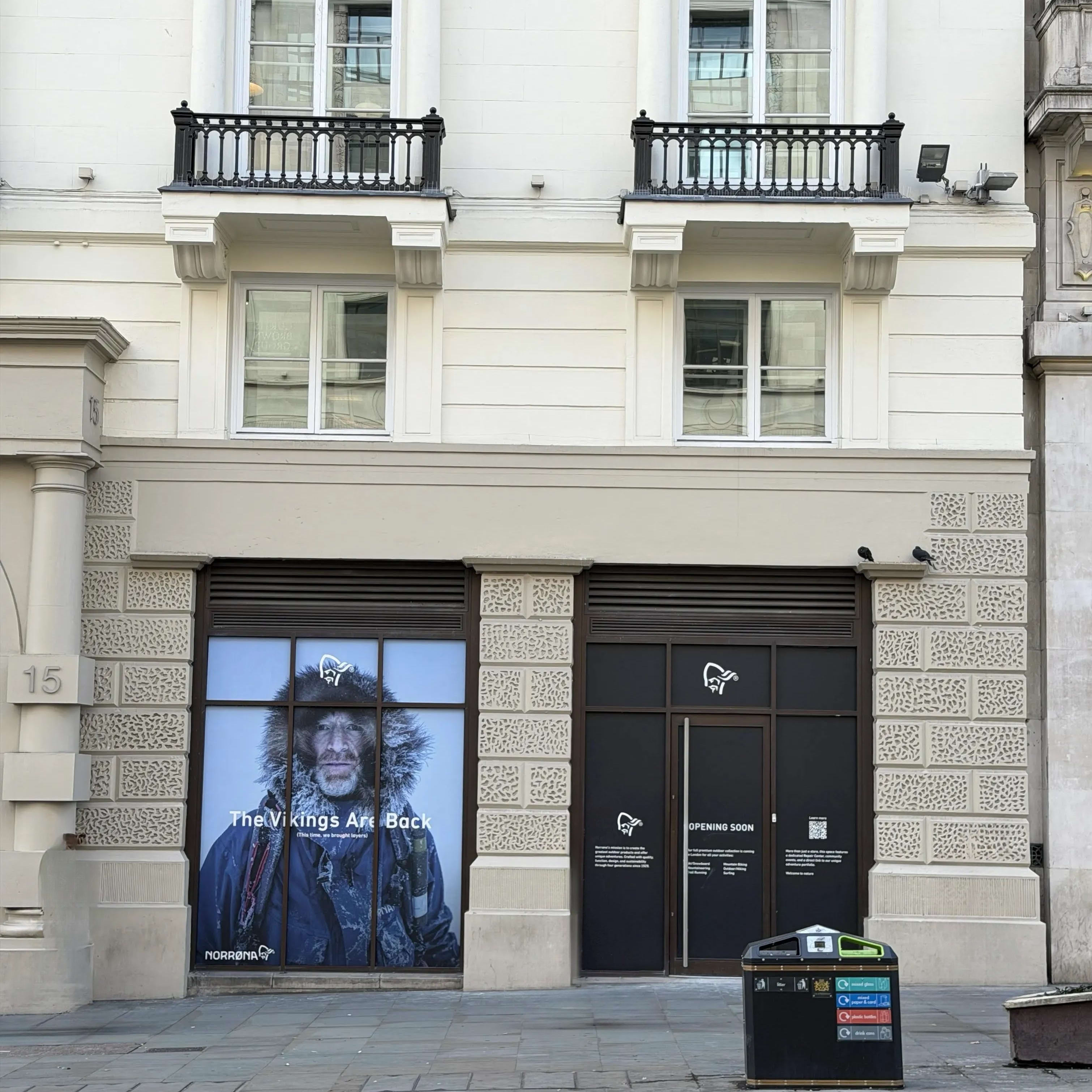 Norrøna storefront with a poster of a man in a Norrøna jacket next to an opening soon sign.
