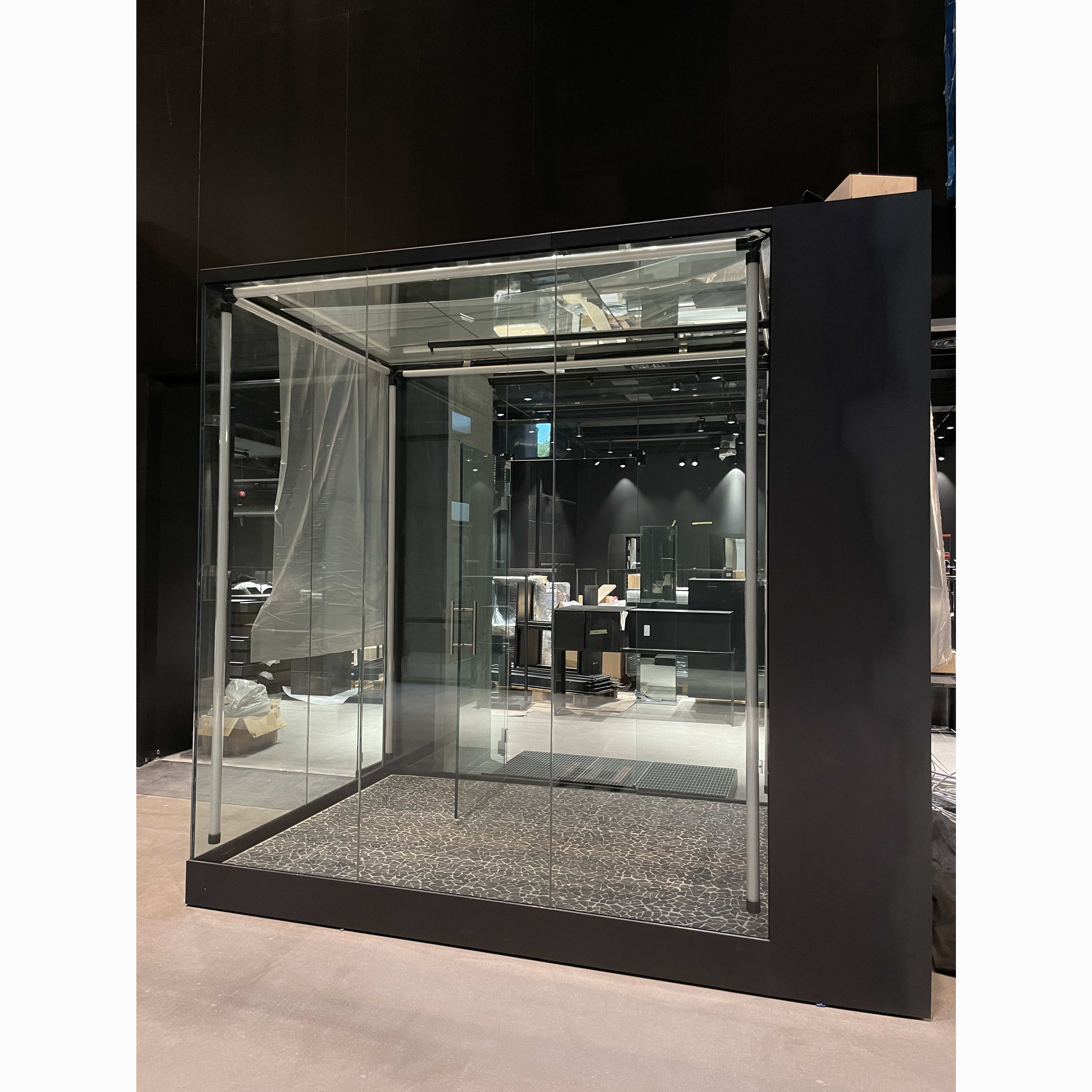 A glass-enclosed display case with shelves and Norrøna clothing inside.