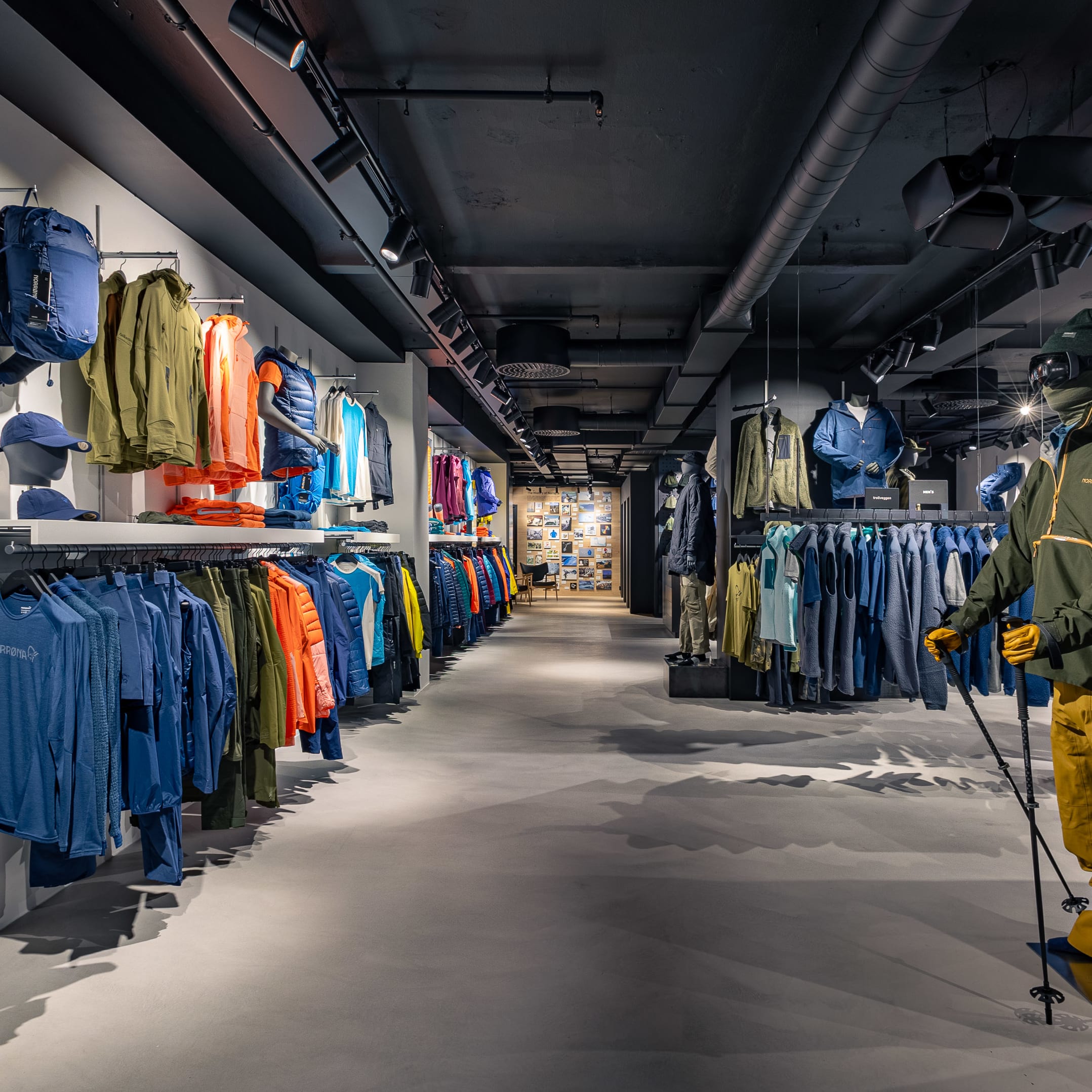 Norrøna retail store interior featuring racks of colorful outdoor apparel and a mannequin in ski gear.