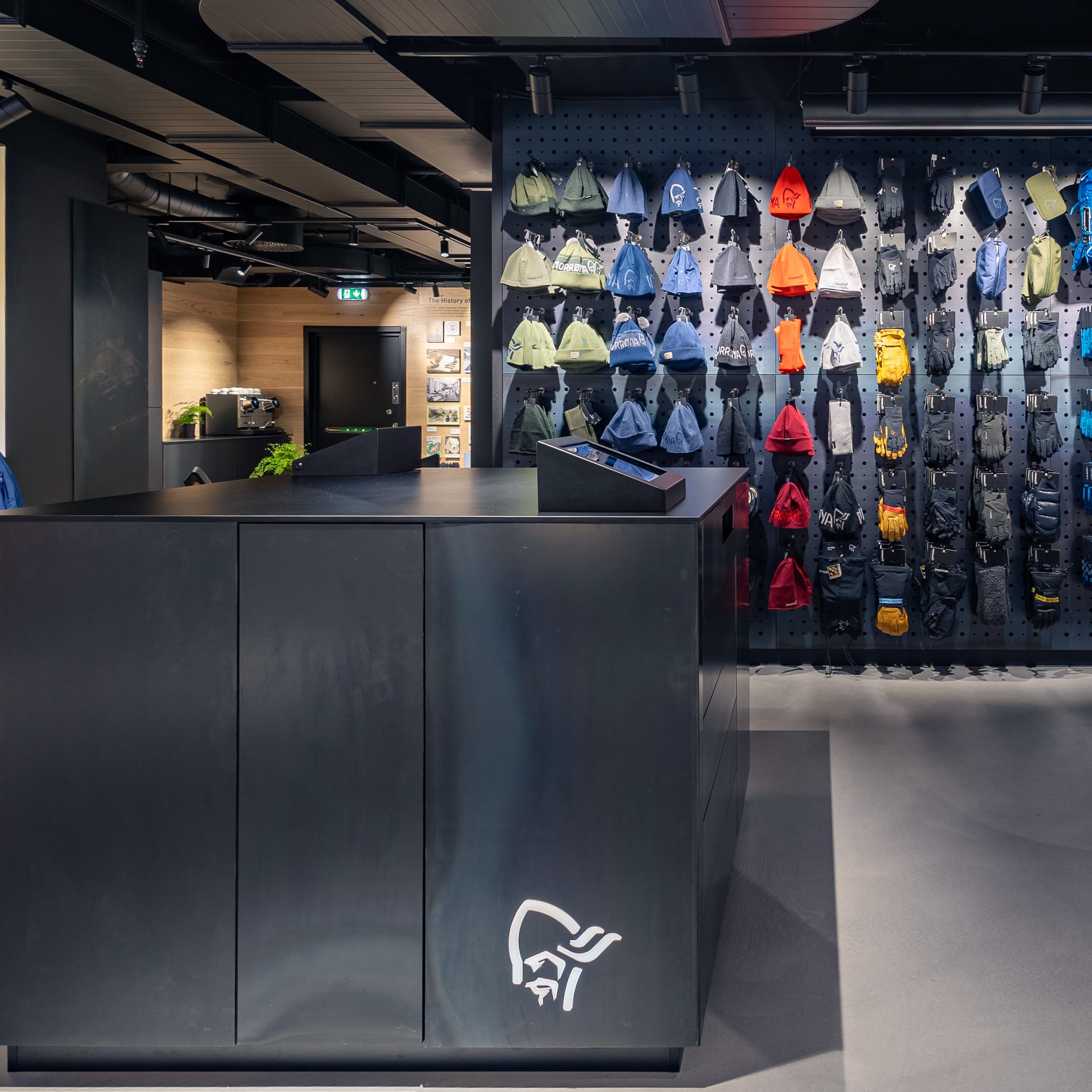 Norrøna store interior with a black counter and displays of Norrøna jackets, hats, and outdoor gear.