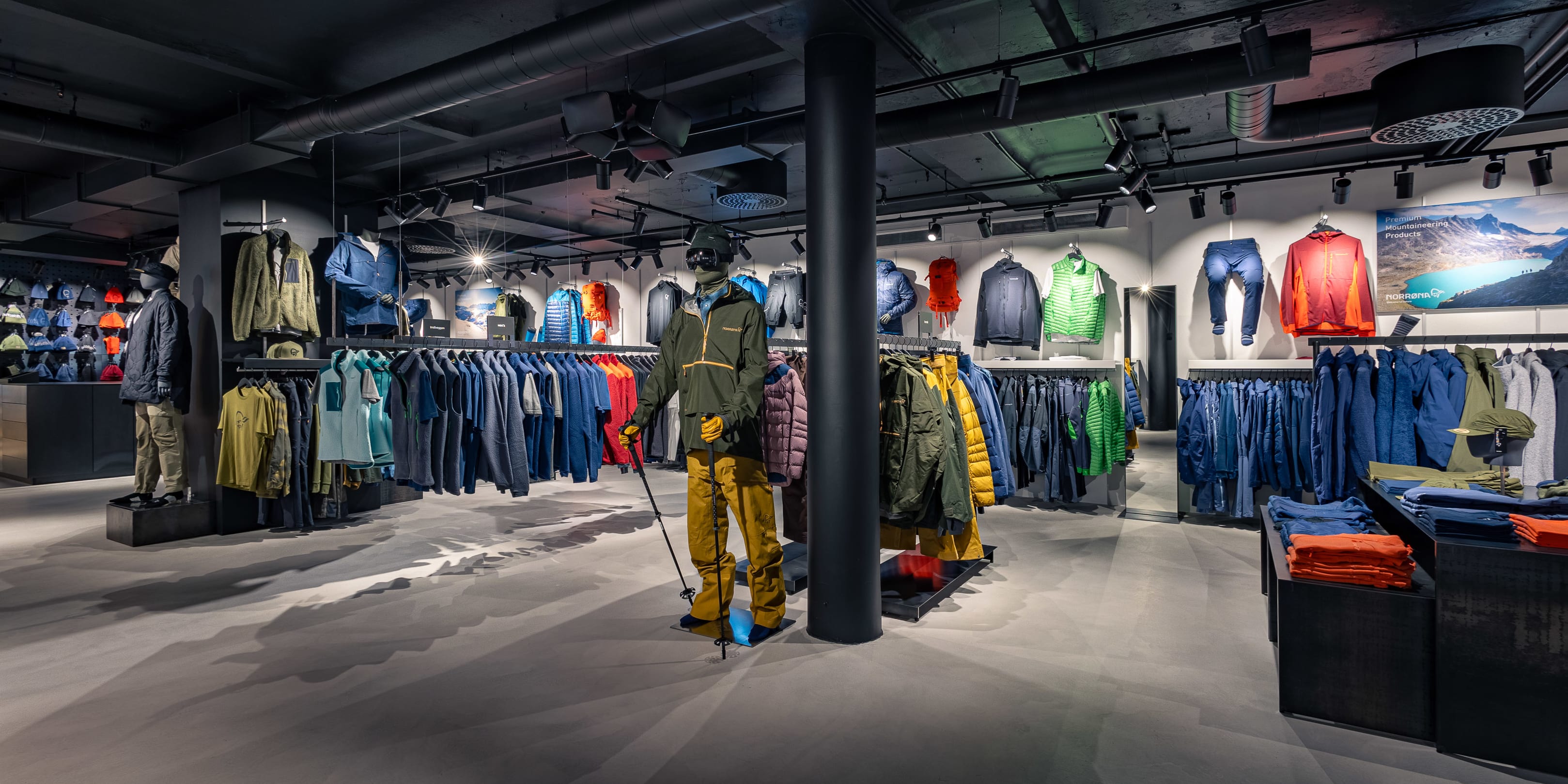 Interior of a Norrøna store displaying colorful outdoor apparel on clothing racks and mannequins.