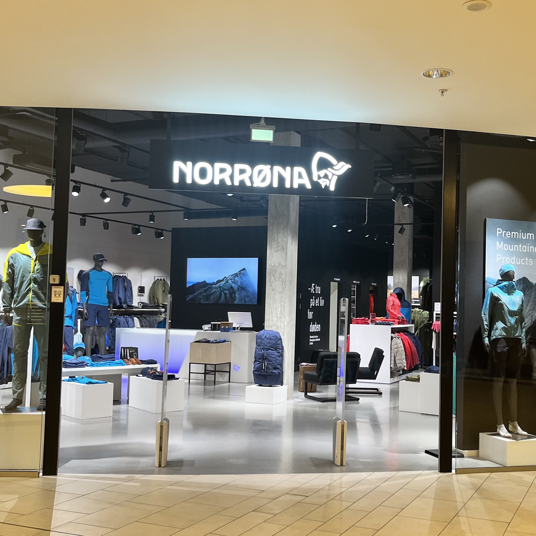 Storefront of a Norrøna retail store with mannequins displaying Norrøna outdoor clothing.