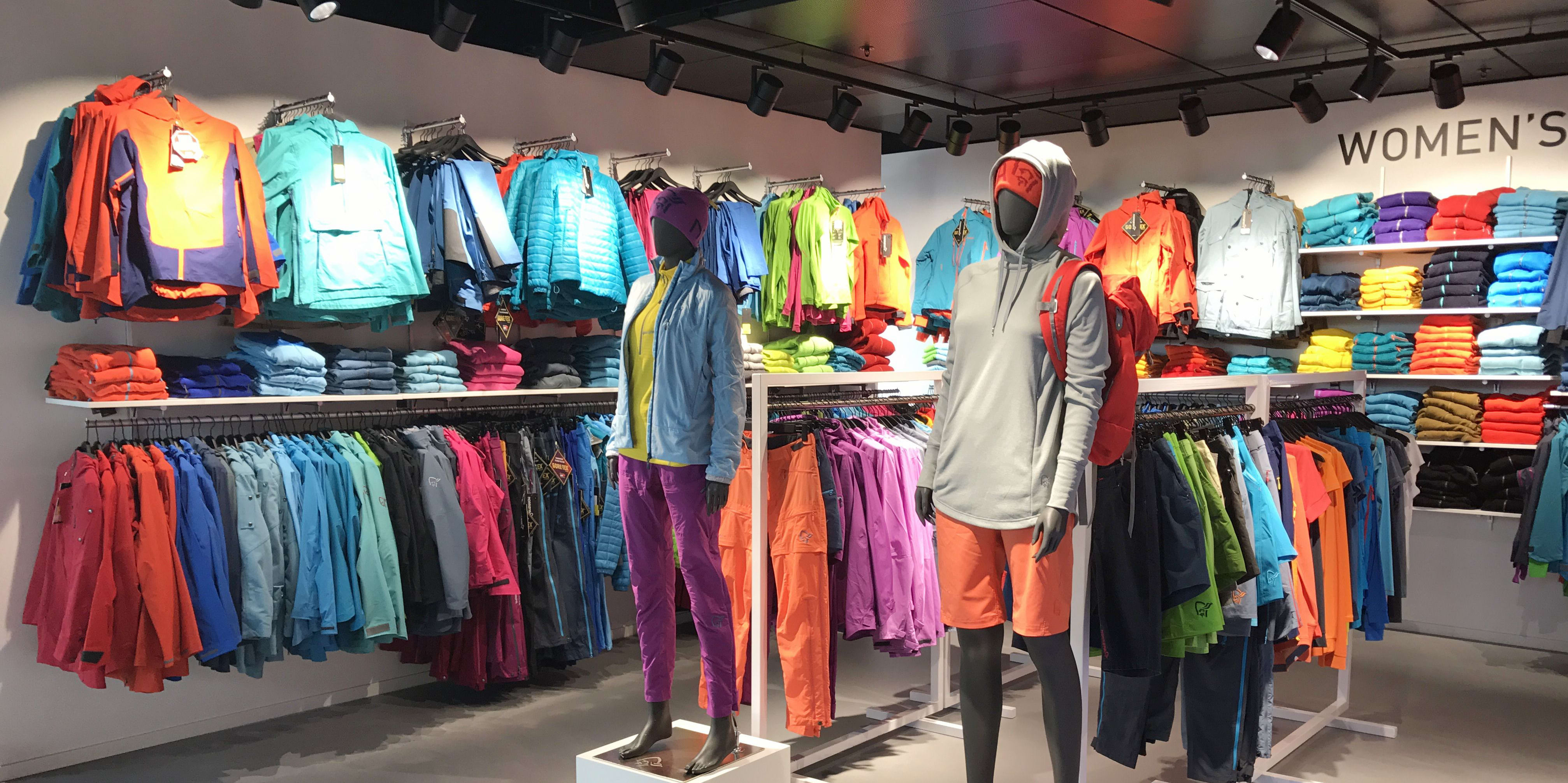 Mannequins displaying colorful Norrøna outdoor clothing inside a retail store.