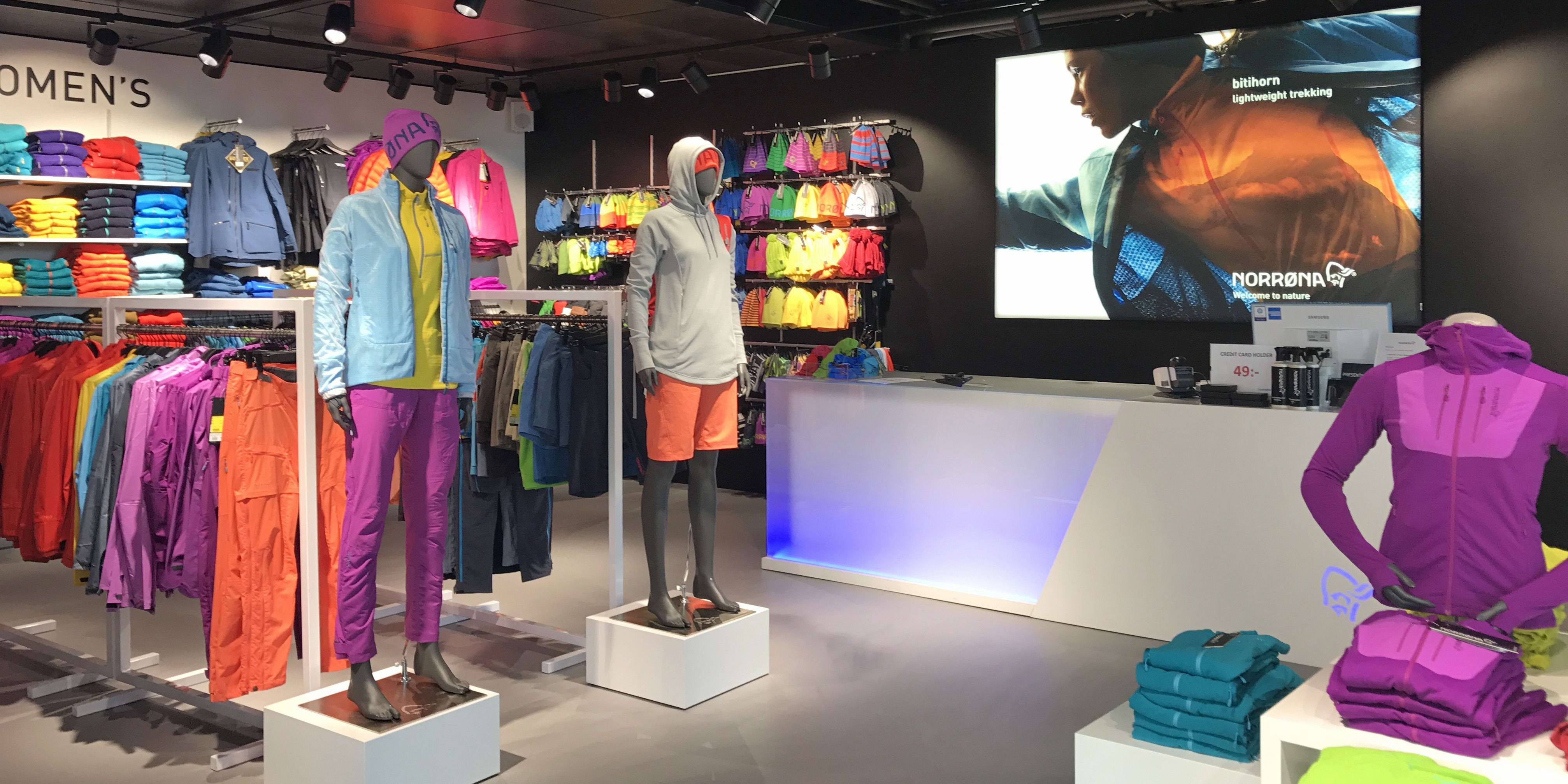 Norrøna store interior with colorful outdoor clothing displayed on mannequins and racks.