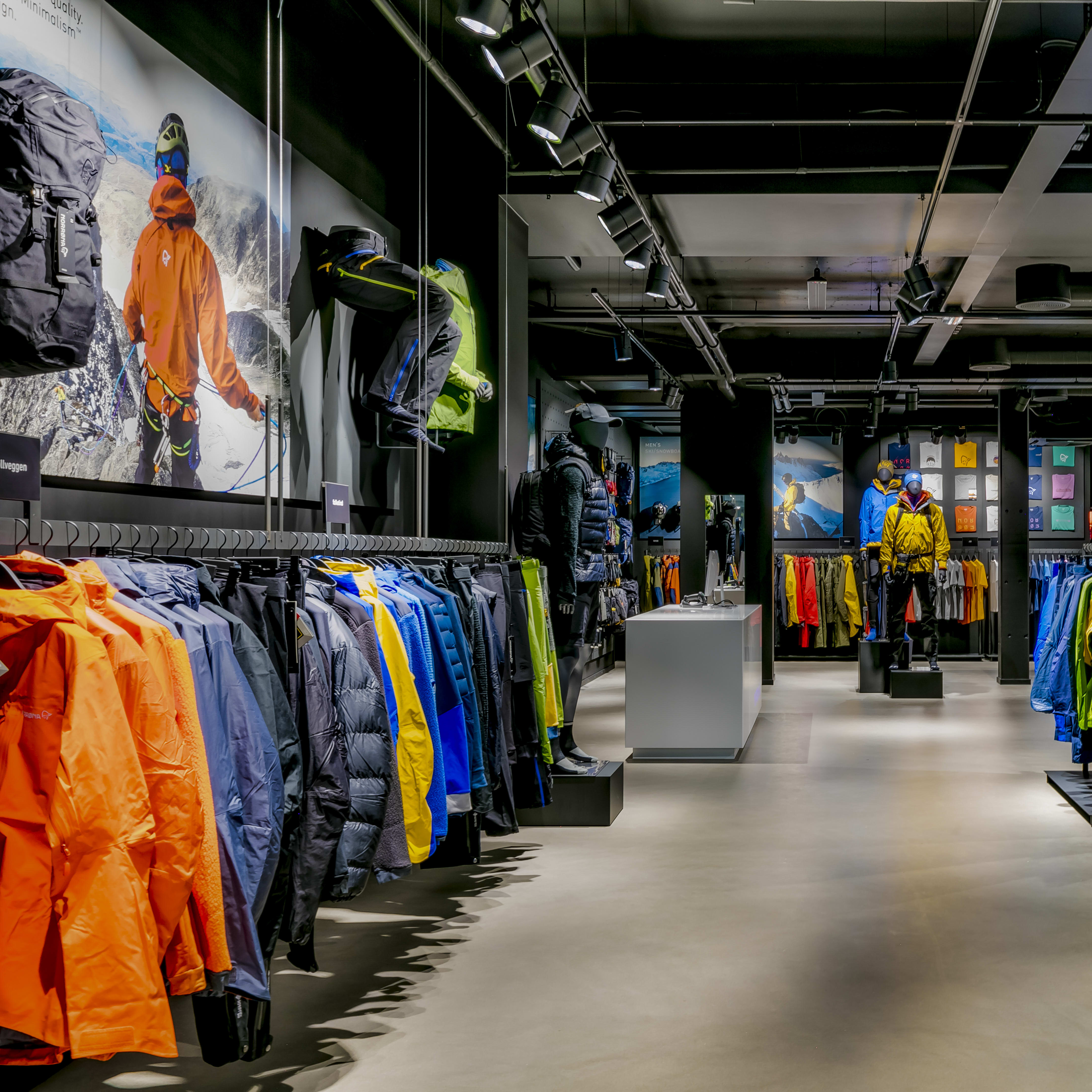 Modern Norrøna store interior displaying colorful outdoor apparel on racks and mannequins.