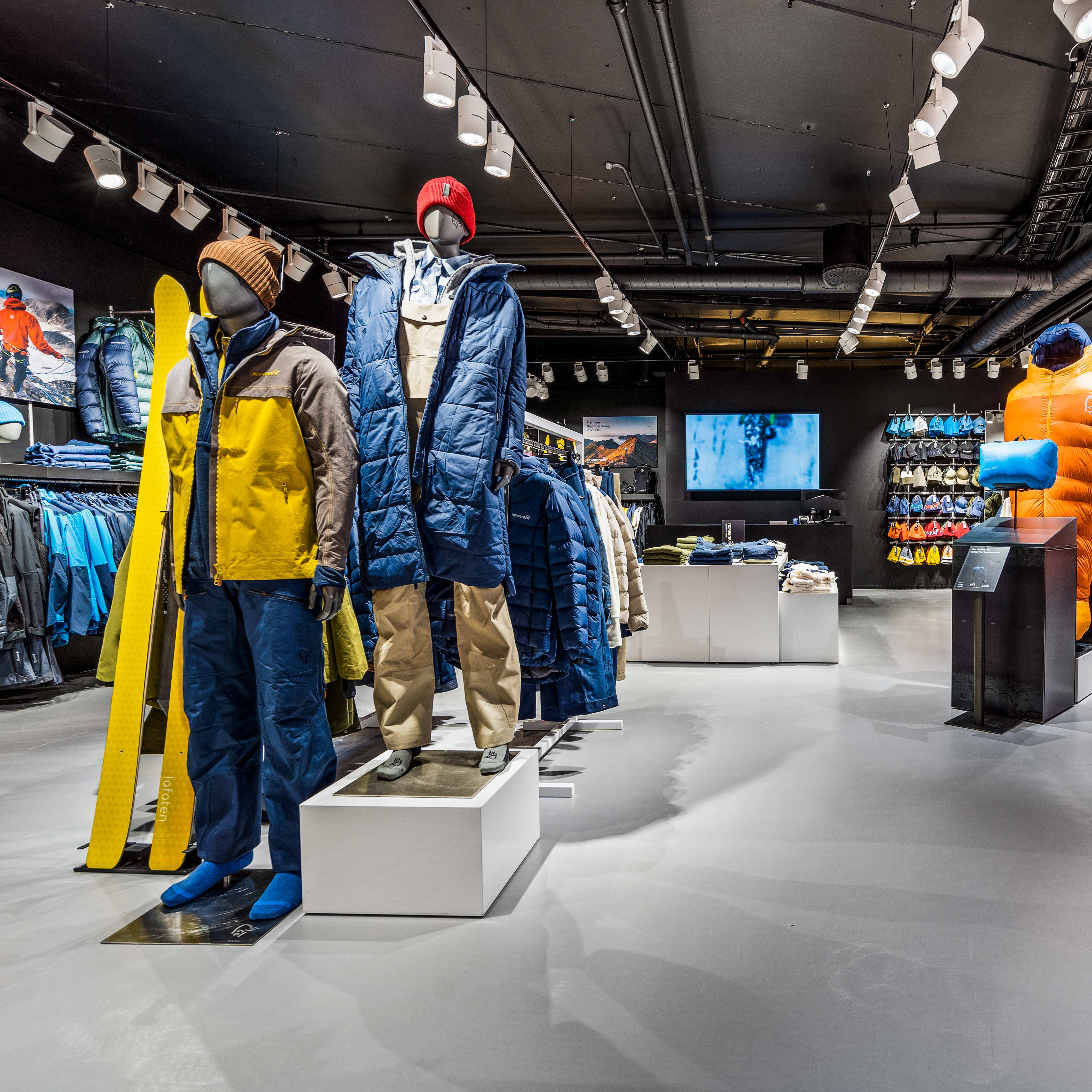 Modern retail store interior showcasing colorful Norrøna outdoor clothing on mannequins and racks.