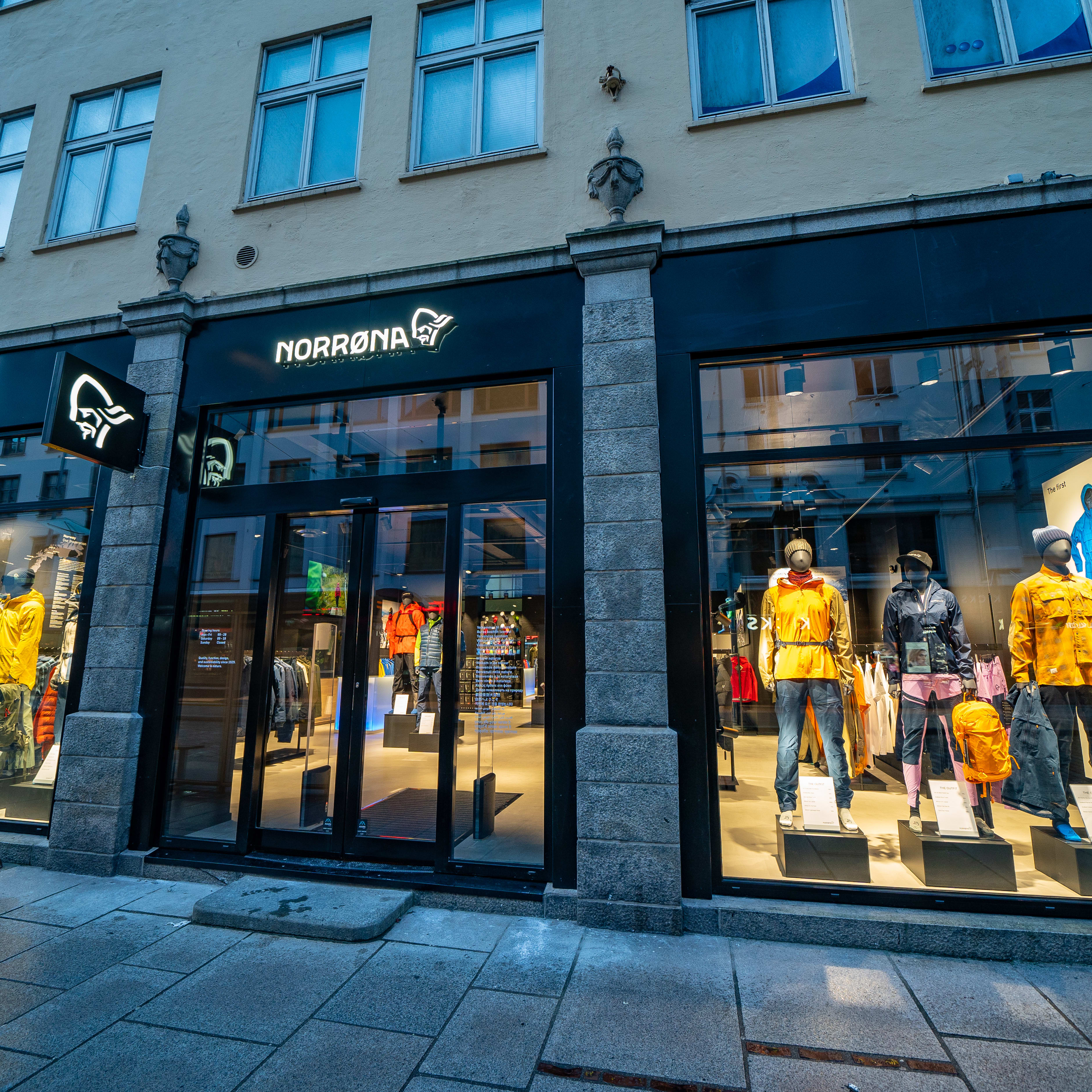 A storefront with the Norrøna logo. Mannequins wearing Norrøna clothing are displayed in the window.