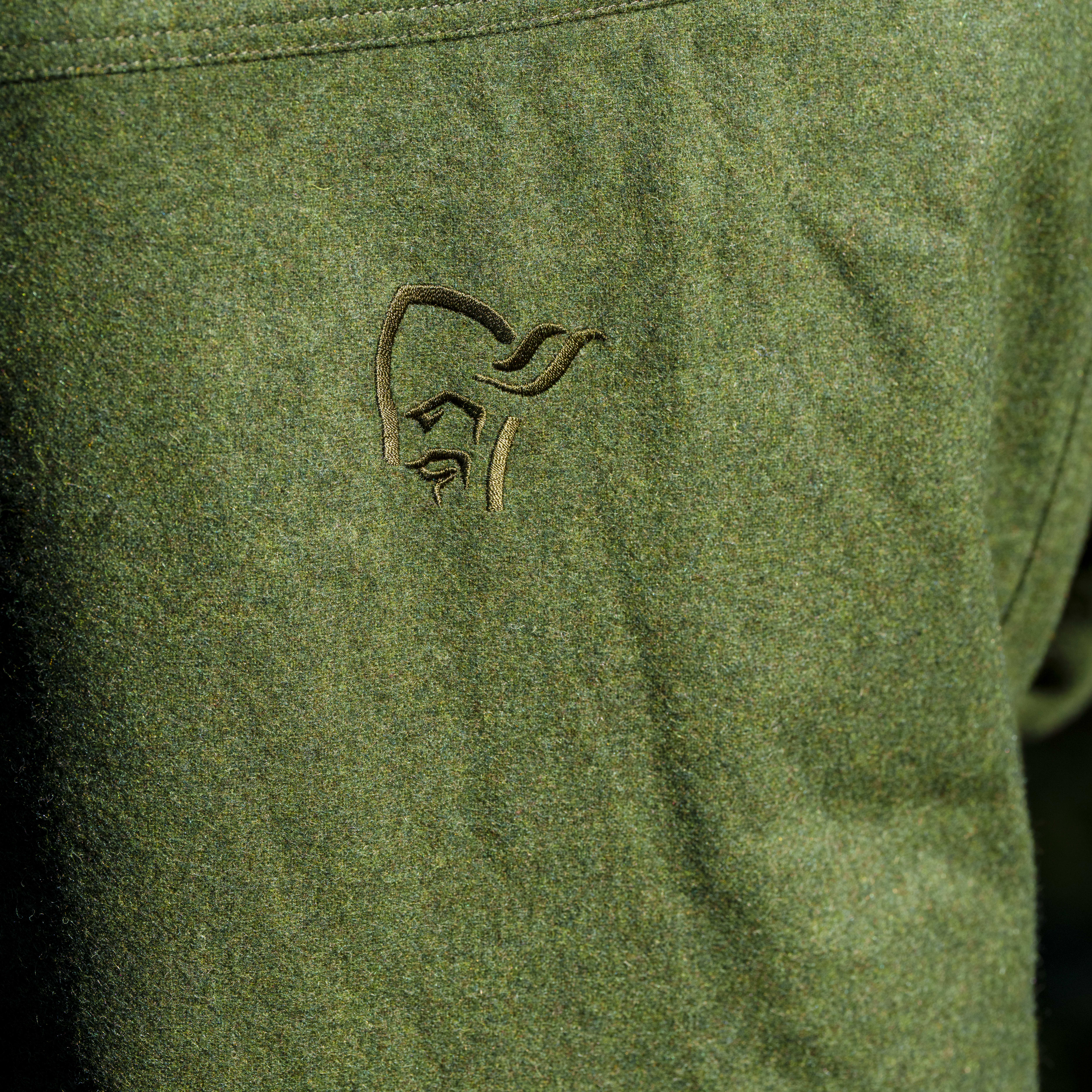 Close up of the Norrøna logo on a green jacket.