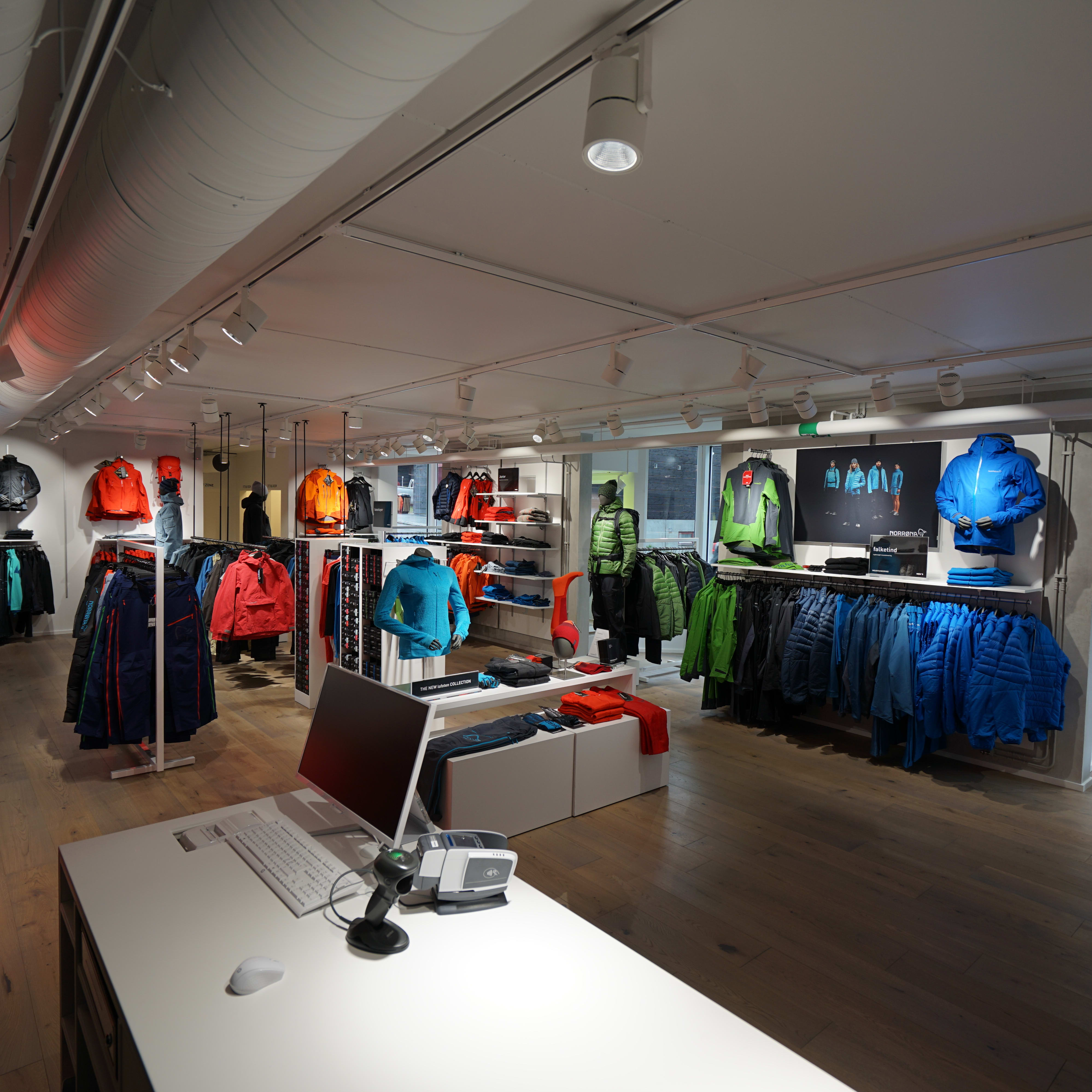 Modern retail store interior displaying vibrant Norrøna outdoor clothing on racks and mannequins.