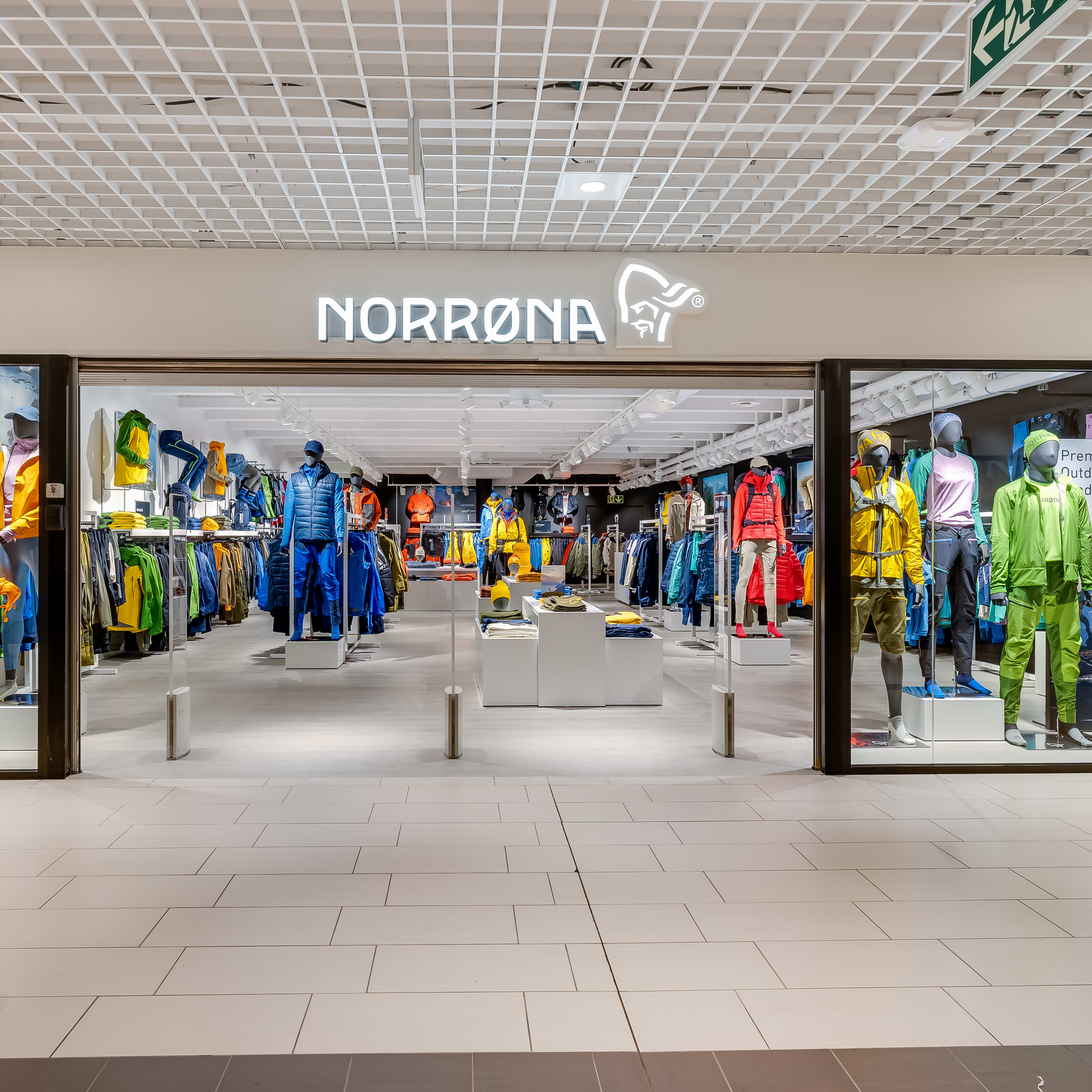 A storefront for Norrøna, an outdoor clothing retailer. Mannequins are displaying outdoor clothing and gear.