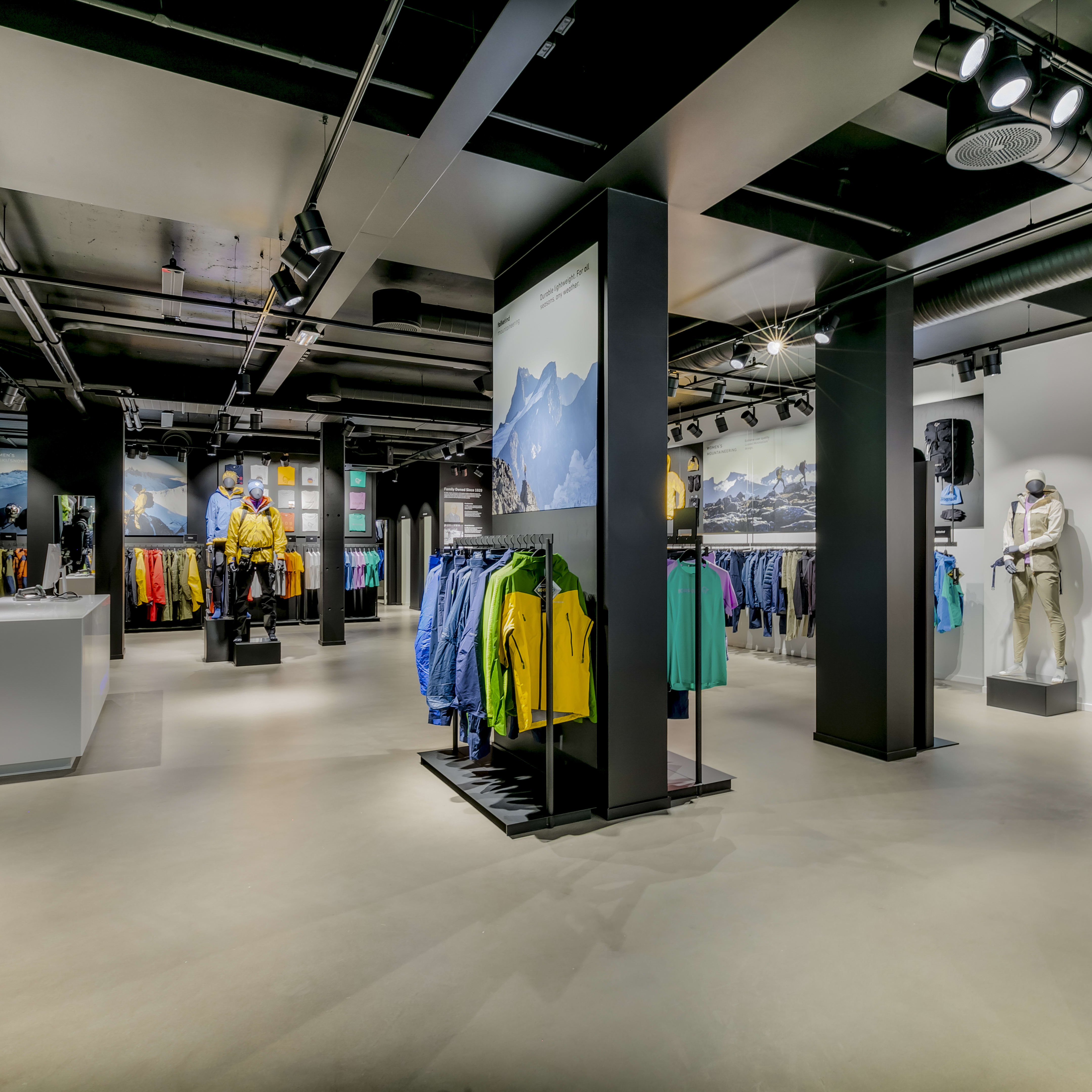 Interior of a Norrøna store featuring outdoor apparel on clothing racks and mannequins.