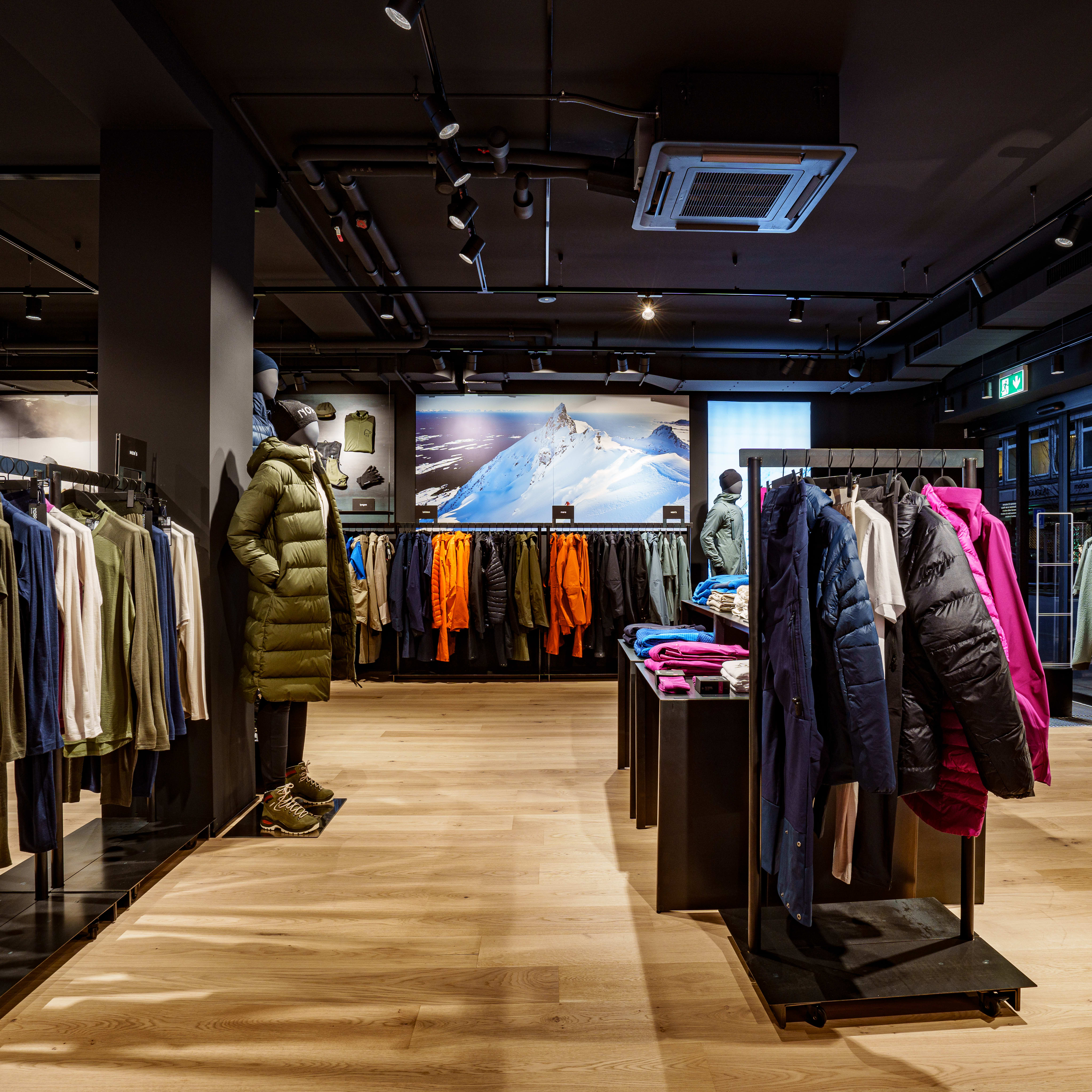 Norrøna clothing store interior with mannequins and clothing displayed on racks.  
