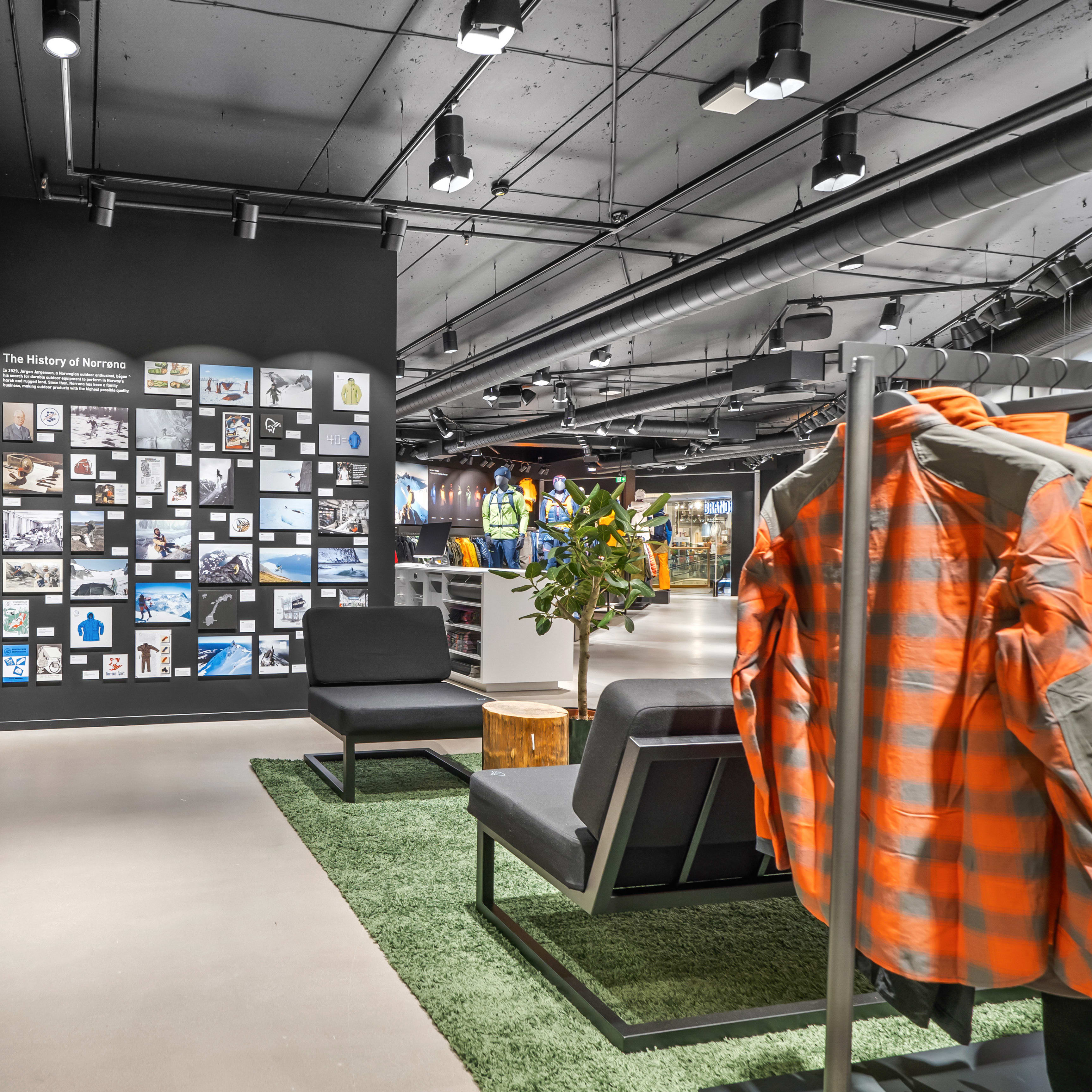 Norrøna store interior with a history display wall, lounge chairs, and a Norrøna jacket on a rack.