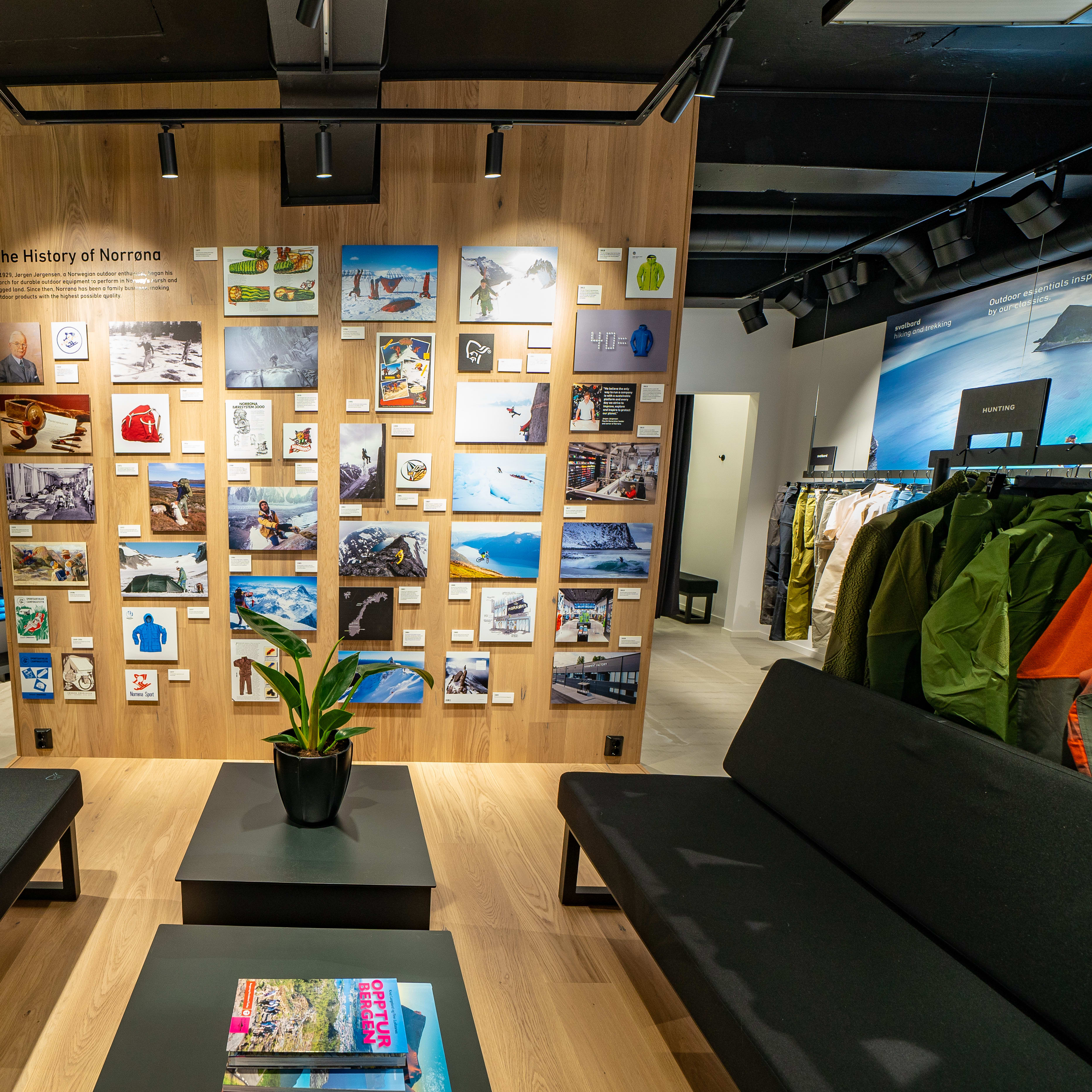 Inside a Norrøna store featuring a history photo wall, lounge seating, and racks of Norrøna products.