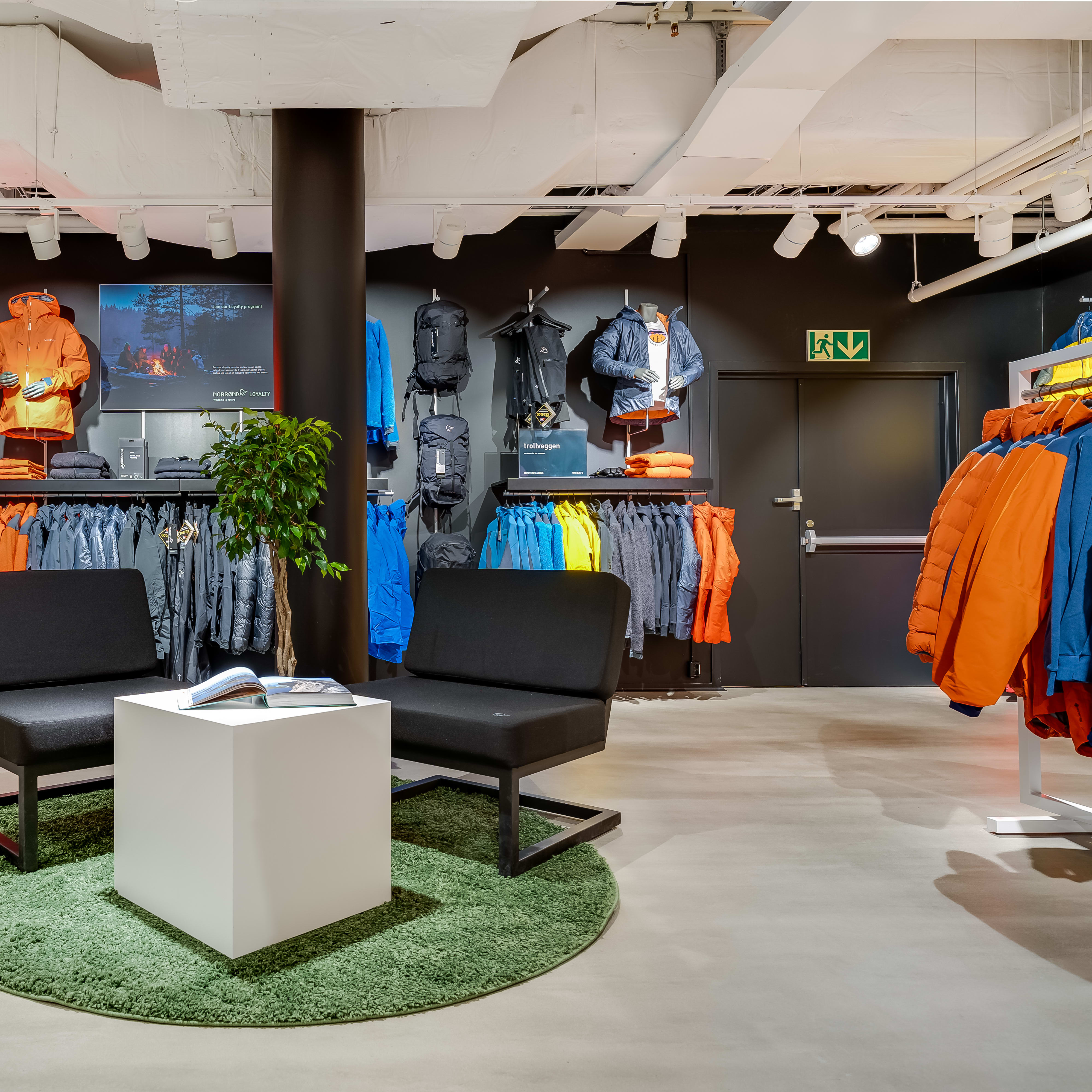 Norrøna store interior with colorful jackets on display and a central seating area.