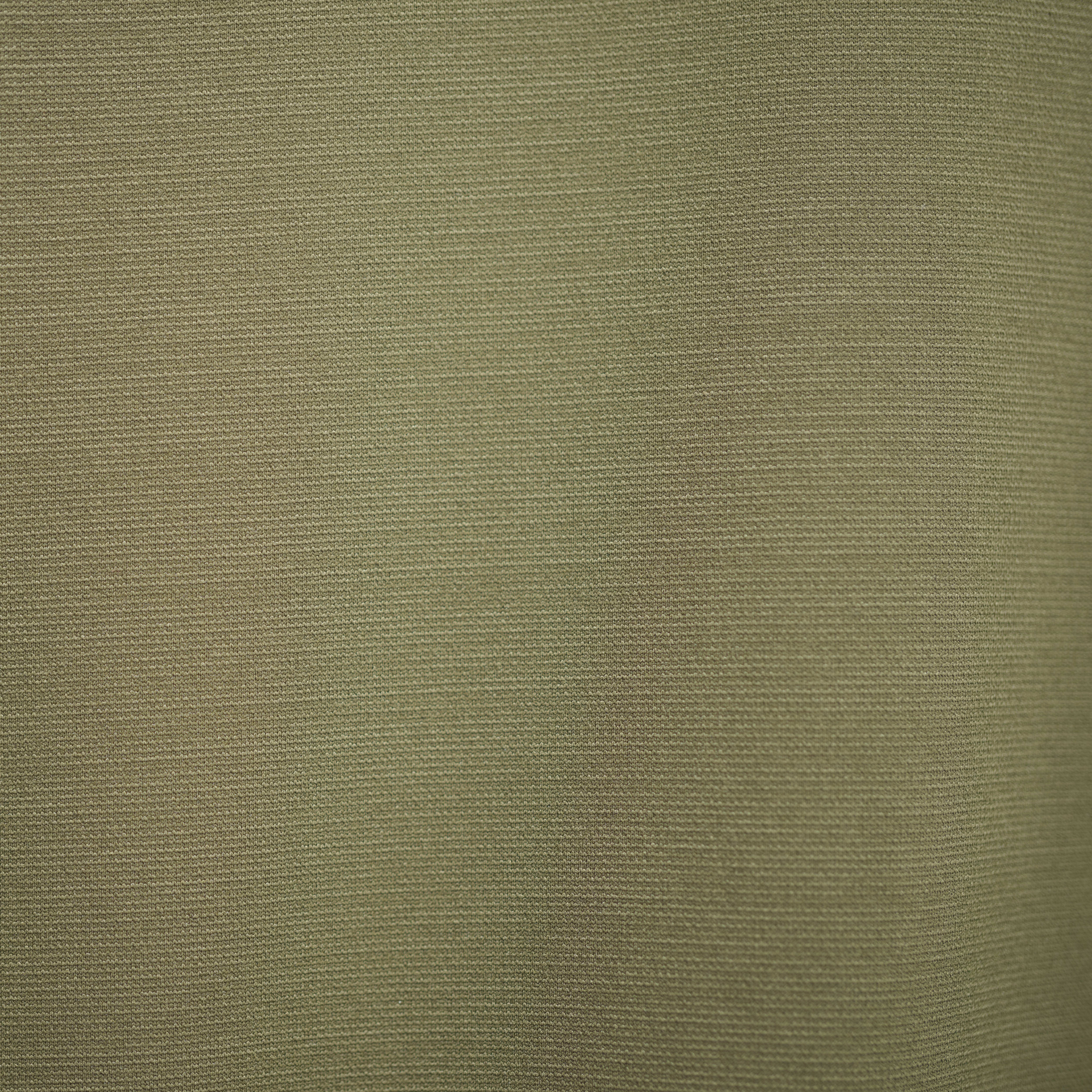 Close-up of the textured surface of a green Norrøna garment. 
