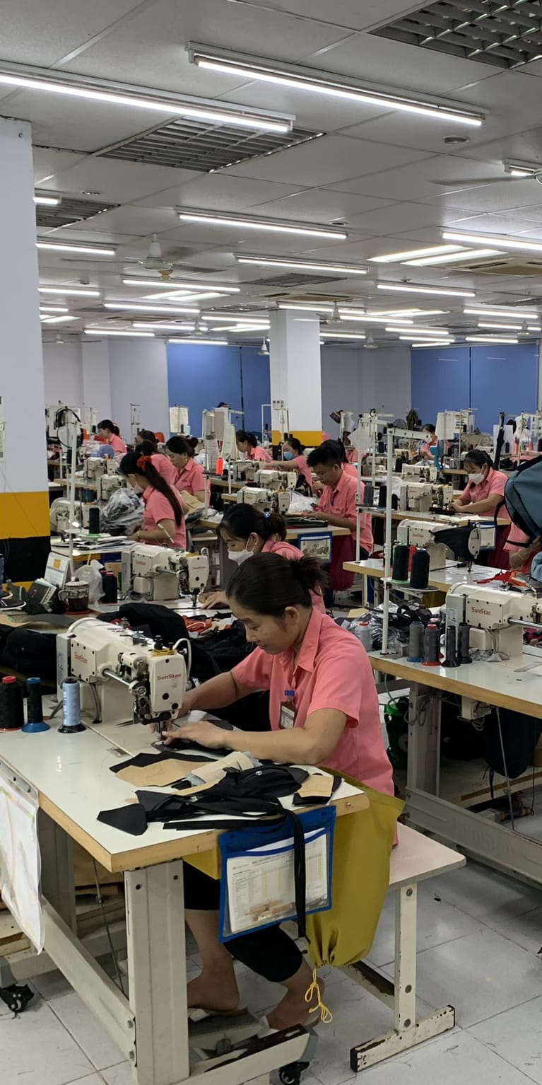 A factory floor with several people sewing Norrøna products. 
