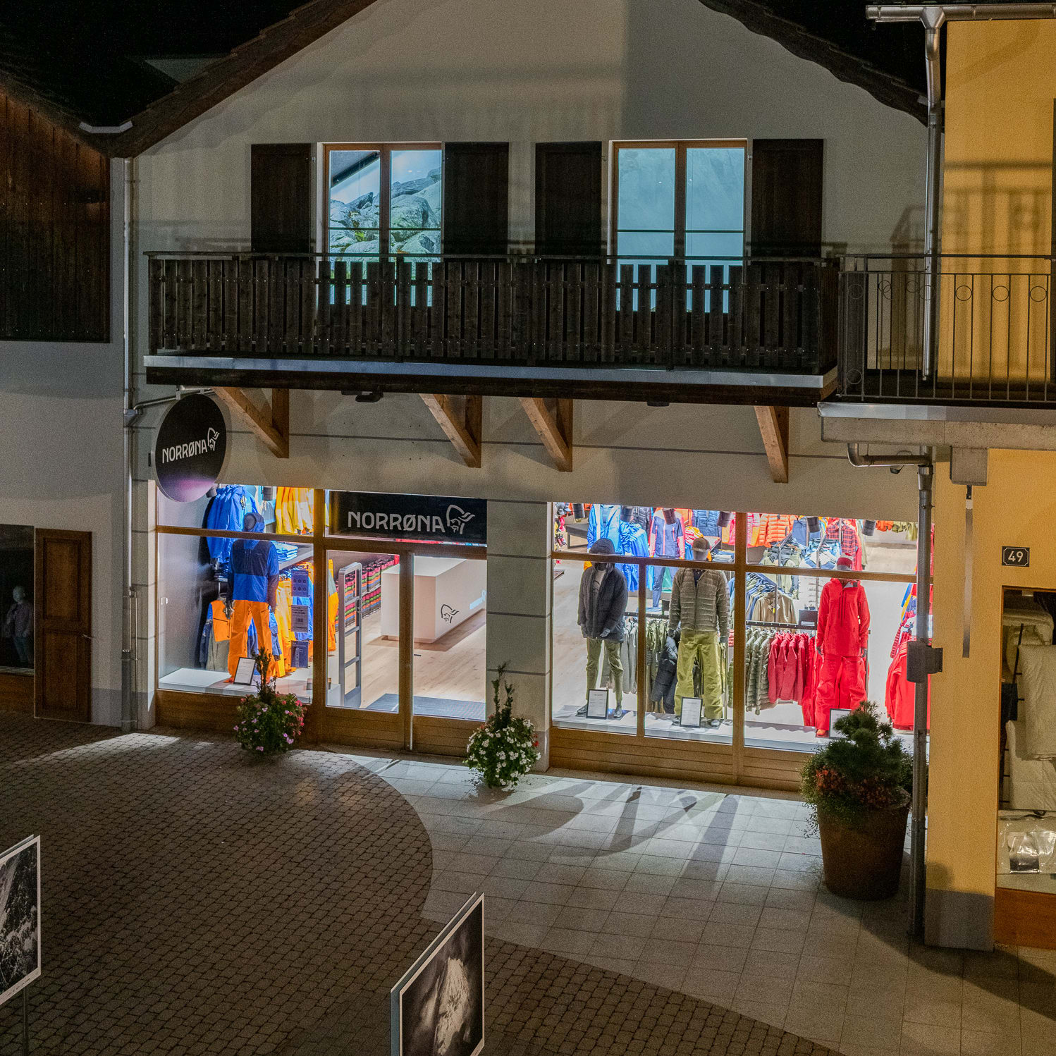 Norrøna retail store at night with mannequins wearing colorful Norrøna outdoor clothing in the window.