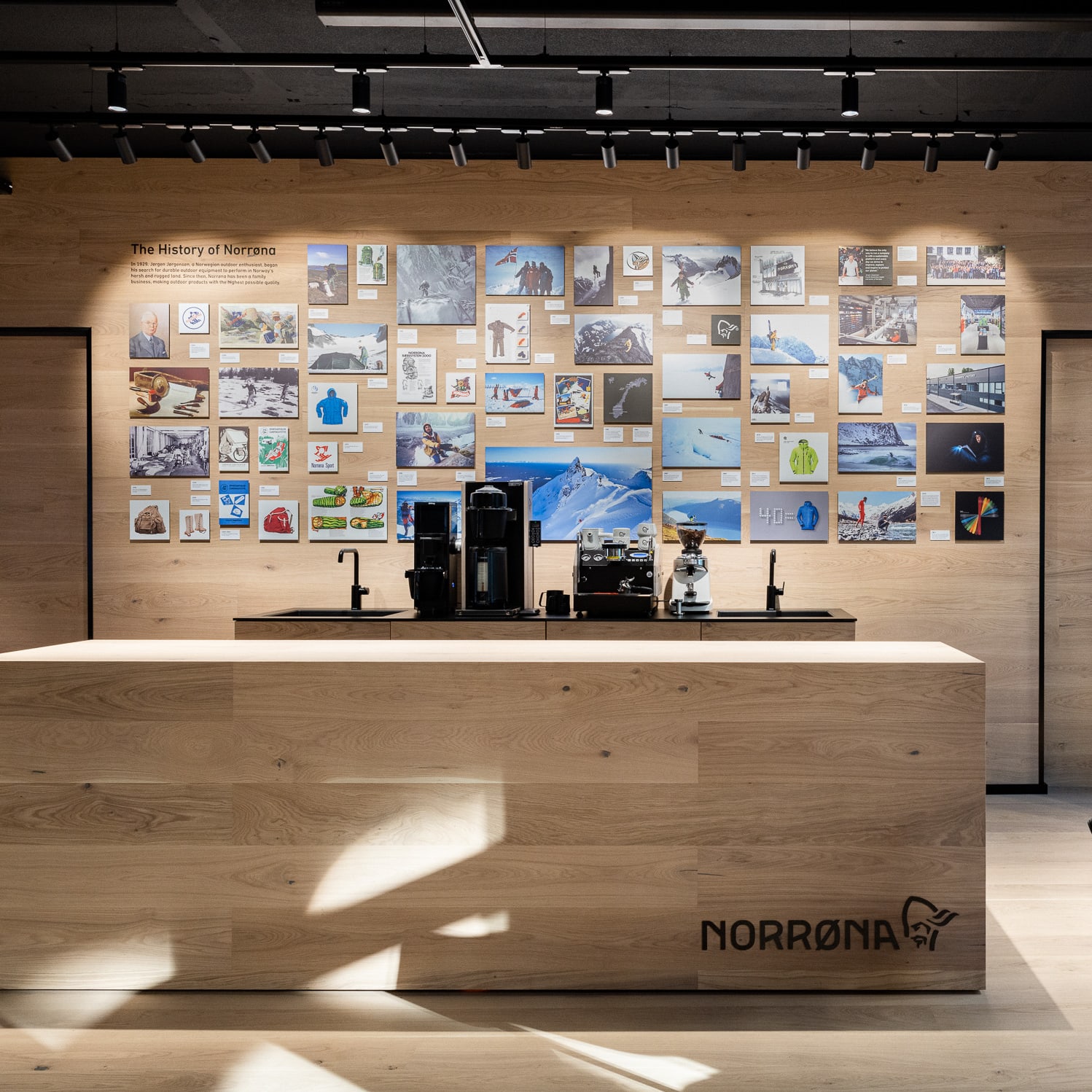 A wooden counter with a Norrøna logo and a wall with photos of the brand's history and products. 
