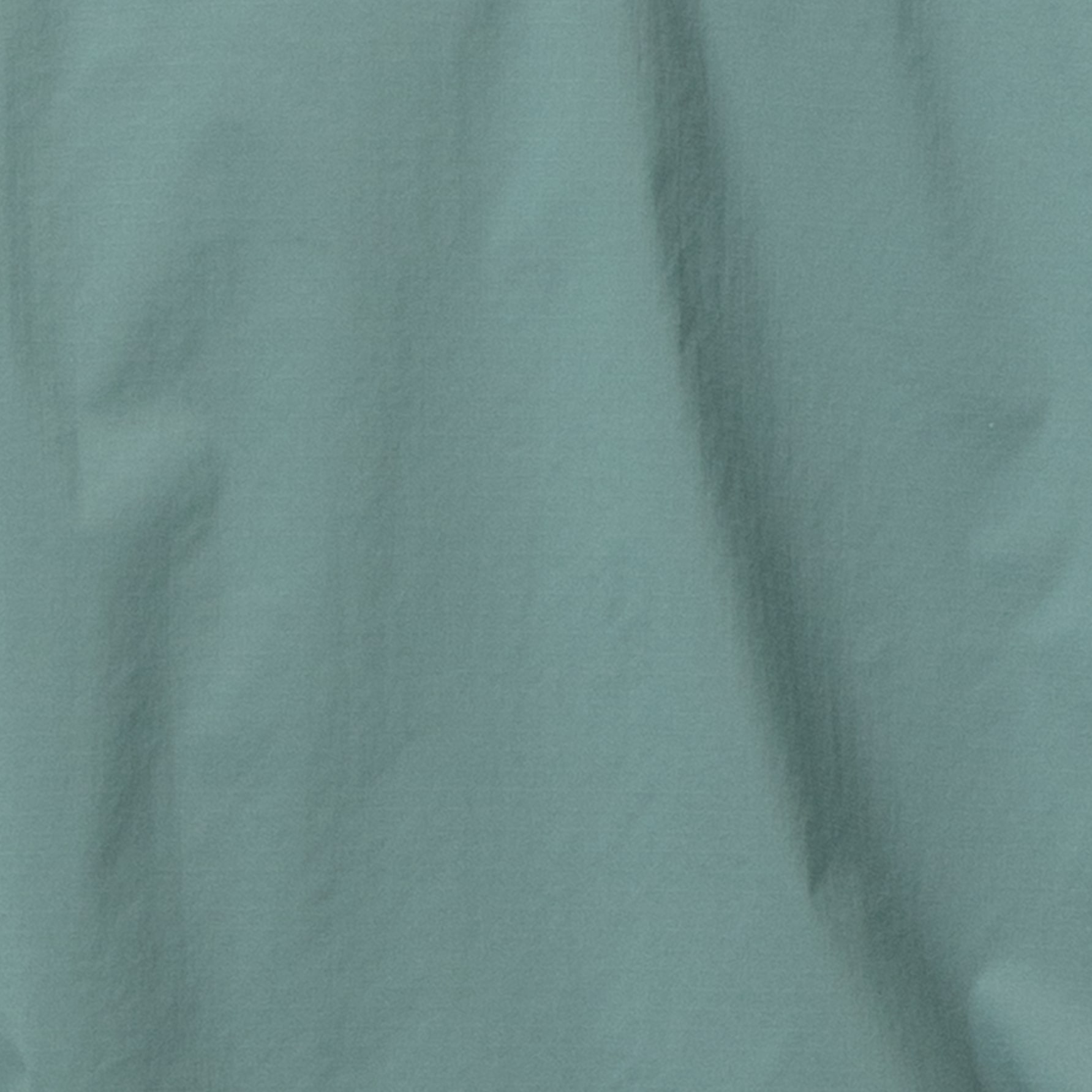 Close up of teal colored Norrøna fabric with wrinkles.