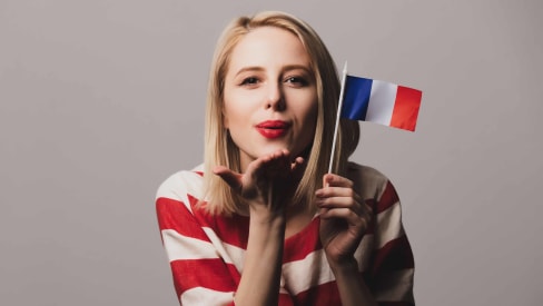 Hand holding a board with ‘Learn french’ written on it