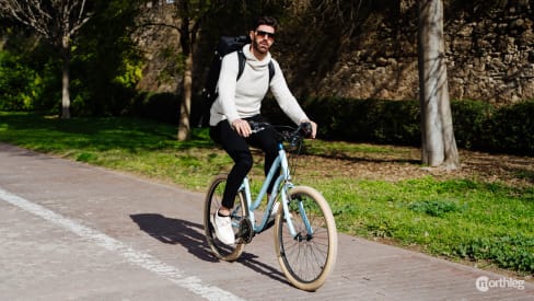 Ciclista con una bici a noleggio a spasso per il Parco Turia di Valencia