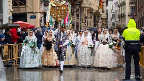 Il portabandiera davanti a una processione di falleras.