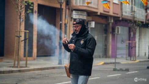 Un hombre encendiendo un petardo en la Despertá - Fallas Valencia