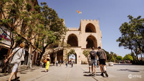 Personas andando por las Torres de Serranos en Valencia