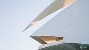 Futuristic white architectural complex with curved, organic shapes resembling a spaceship or modern art installation.