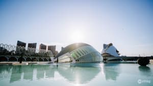 Futuristic white architectural complex with curved, spaceship-like buildings against a clear blue sky in Valencia, Spain.