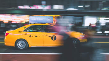 Taxi de Nueva York con gente borrosa en movimiento en primer plano