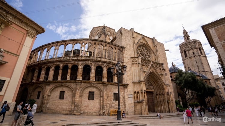 Valencia Cathedral viewed from Plaza de la Virgen, showcasing intricate architectural details against a bright blue sky