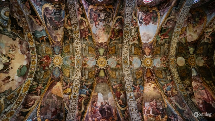 Ornate baroque ceiling fresco with intricate religious paintings inside the San Nicolas Church in Valencia, Spain.