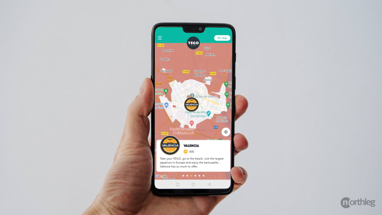 Smartphone screen displaying the YEGO scooter rental app map of Valencia with color-coded rental zones and location markers.