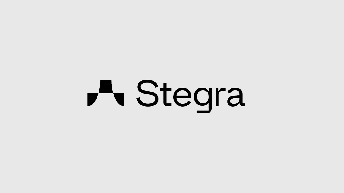 Bilden visar en logotyp bestående av en stiliserad grafisk symbol och texten "Stegra". Den grafiska symbolen, placerad till vänster om texten, är svart och har en abstrakt form med både raka linjer och rundade hörn, liknande en stiliserad bokstav 'A'