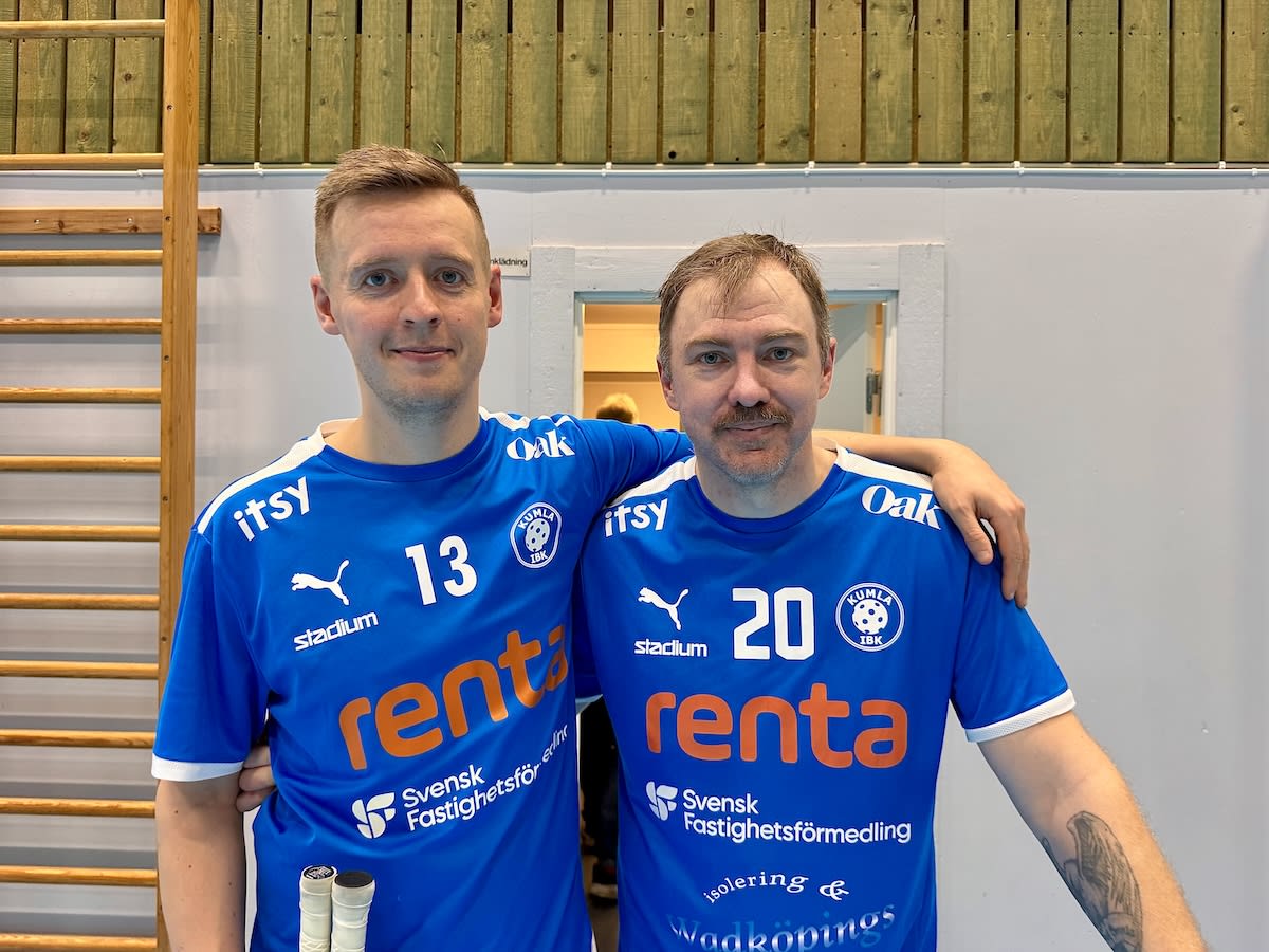 Två män poserar med armarna om varandra, klädda i blåa tröjor med logotyper för Stadium, Renta, Itsy och Kumla IBK. De står inomhus framför en ribbstol och en vit vägg med en öppen dörröppning.