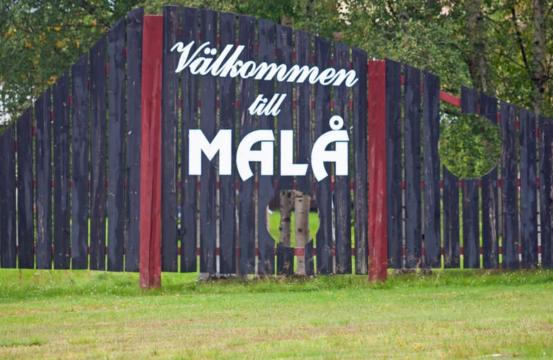 Skylt över samhället som säger välkommen till Malå.