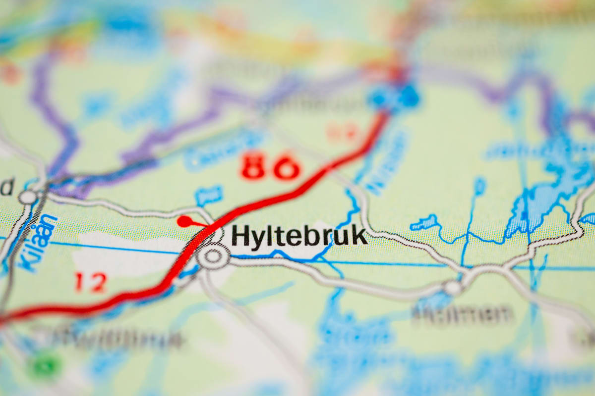 En närbild av en karta med fokus på orten Hyltebruk och de omgivande vägarna samt vattendragen. Gröna landområden, blå vattendrag och röda samt grå vägar är synliga. Vägen märkt "86" är framträdande.