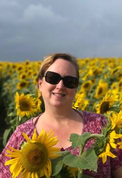 Caren Lewis, administrative assistant at Jaffrey Parks and Recreation Department, in a field of sunflowers. Photo courtesy of Renee Sangermano.