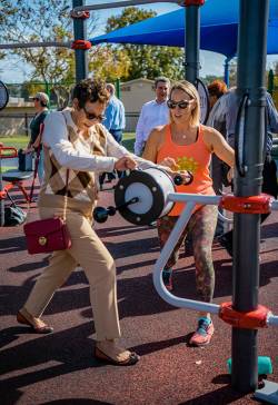 Christie Bruner (left), community engagement supervisor at City of St. Petersburg Parks & Recreation - Healthy St. Pete, helping an AARP board member change the resistance on a hand bike machine. Photo courtesy of Christie Bruner.