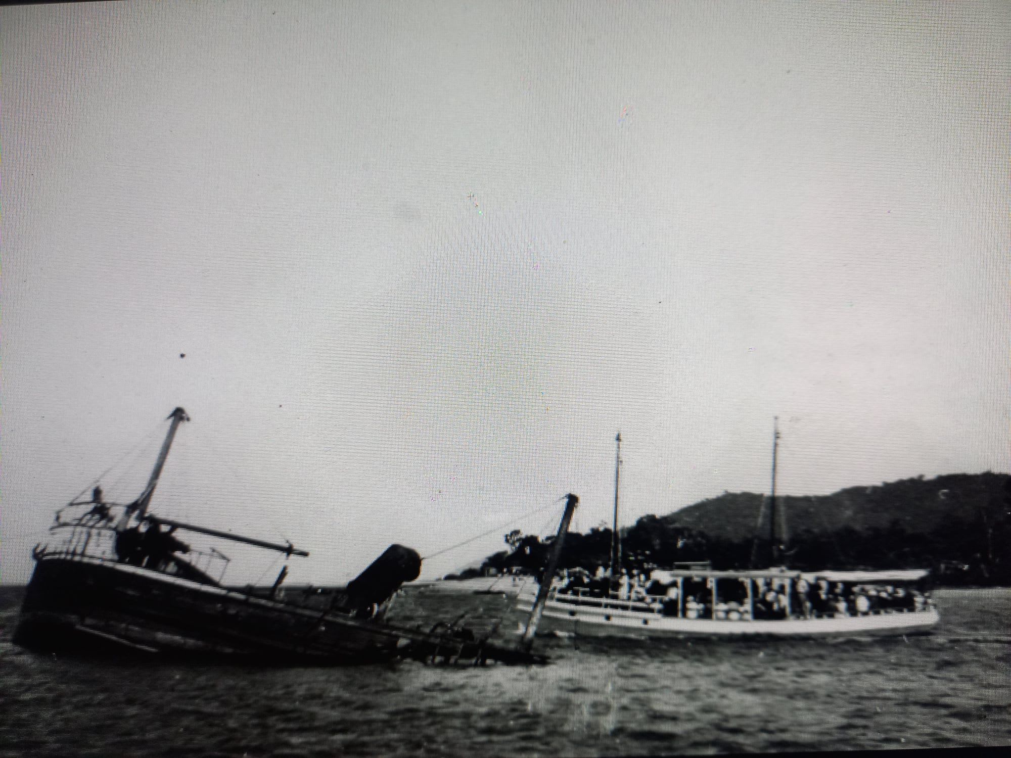 Locals on the " Mandalay " in 1934 pass the wreck of the " SS Tully" which hit a rock at the mouth of the Johnstone River in 1927 and sank