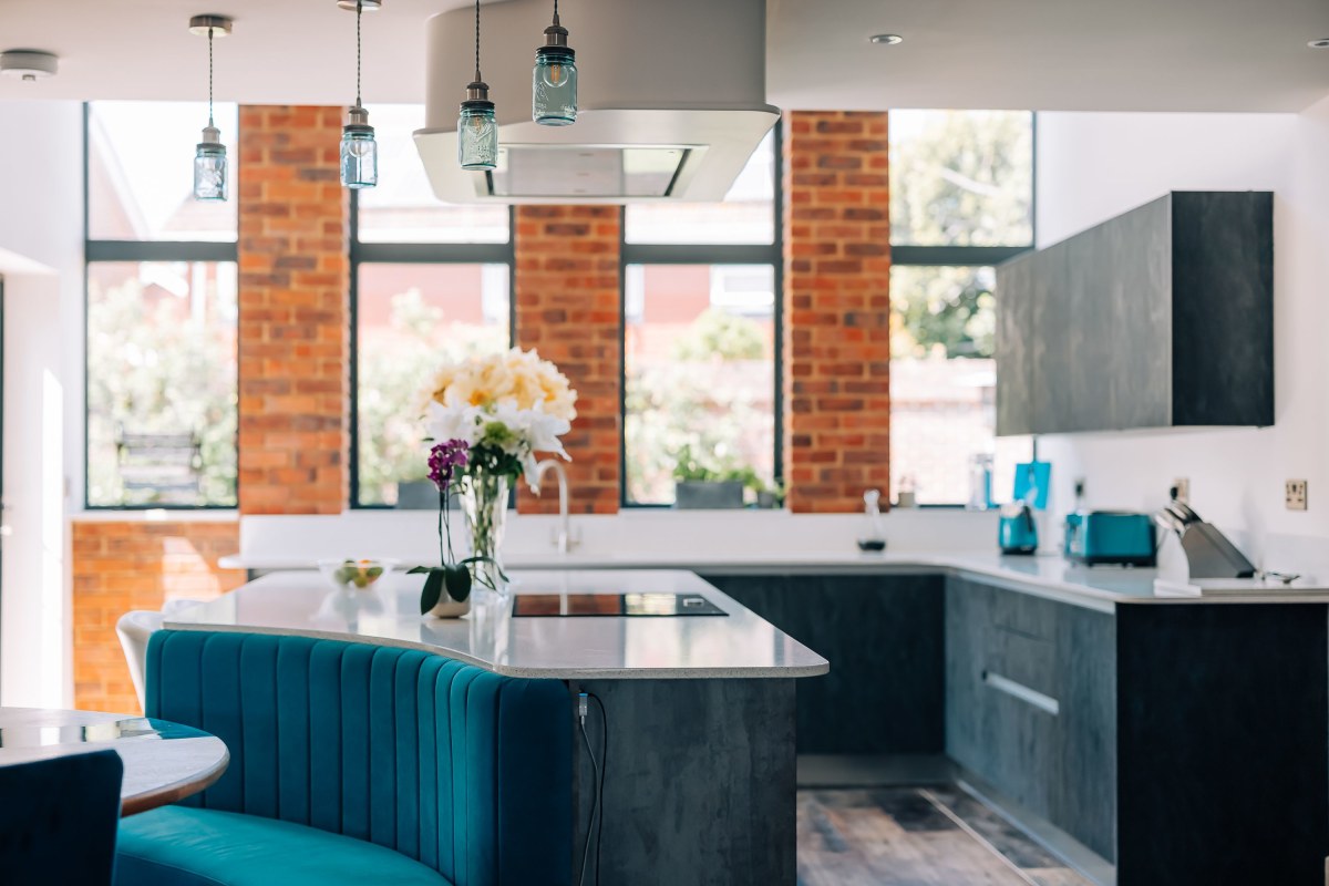 An industrial style modern kitchen in Emsworth with concrete effect cupboards and exposed brickwork