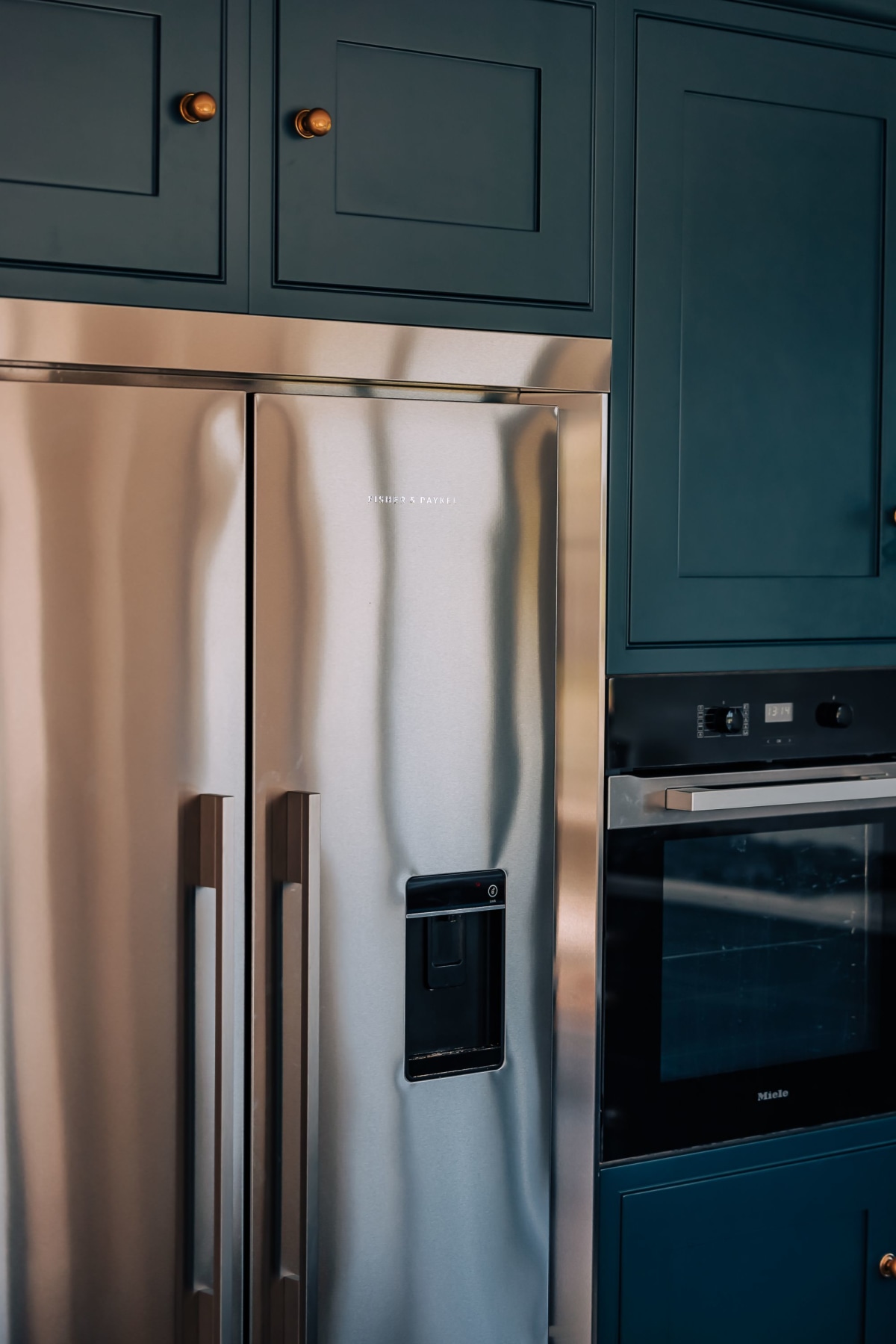 A stainless steel American Fridge Freezer inset in a dark blue kitchen wall