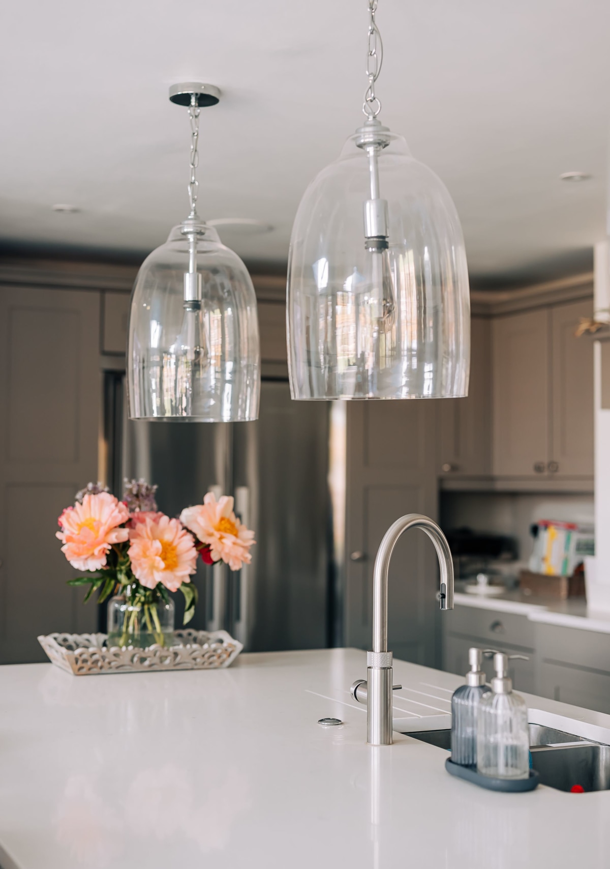 A kitchen island with two feature glass pendant lights above