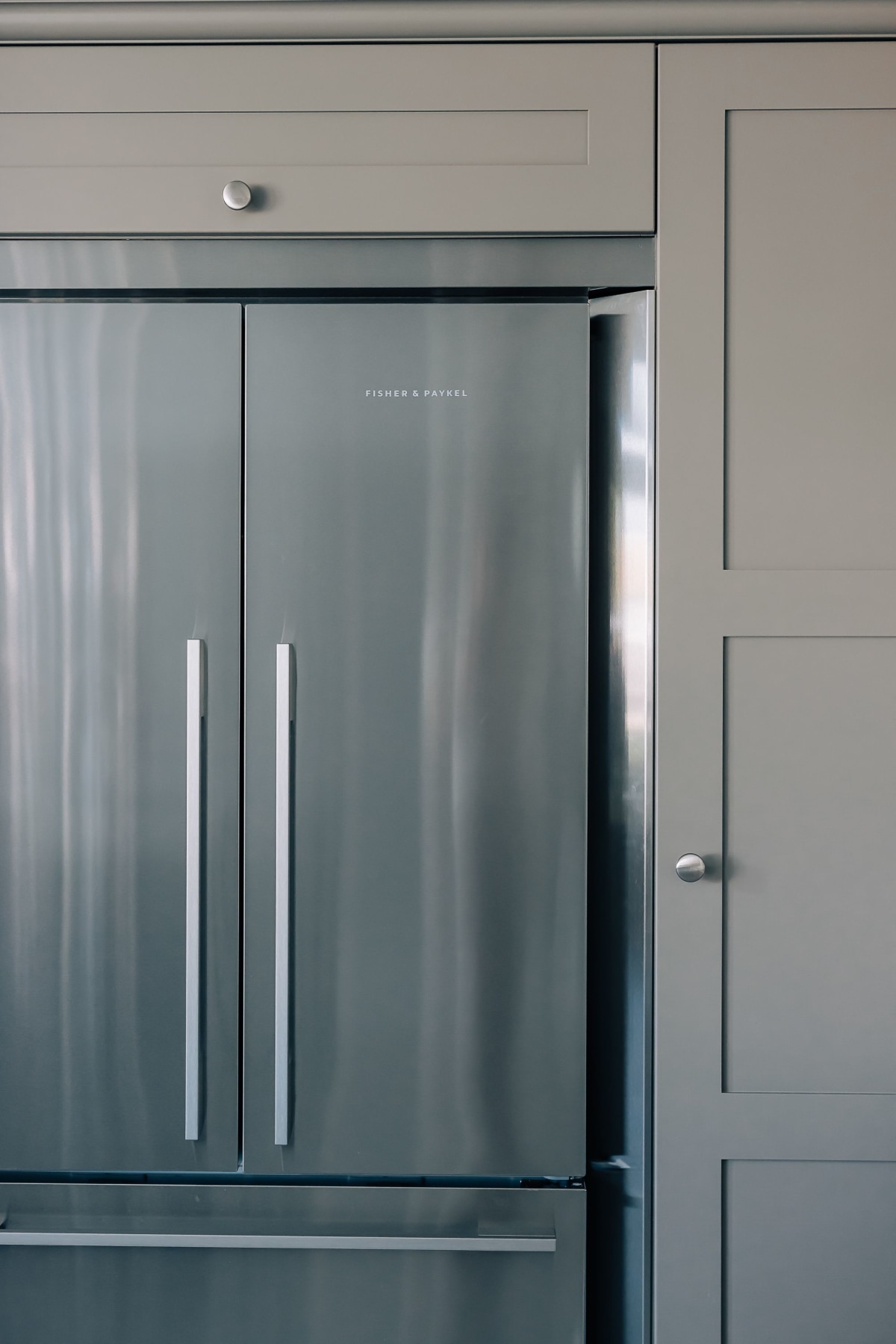A Stainless Steel Fisher and Paykel American Fridge Freezer built in to a shaker kitchen