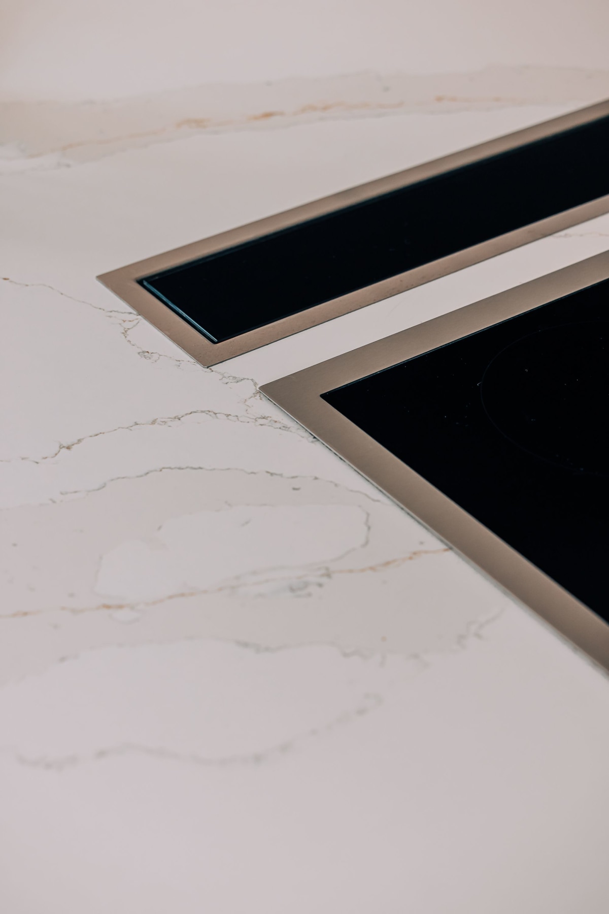 A Gaggenau downdraft extractor and induction hob inset into a white marbled quartz worktop