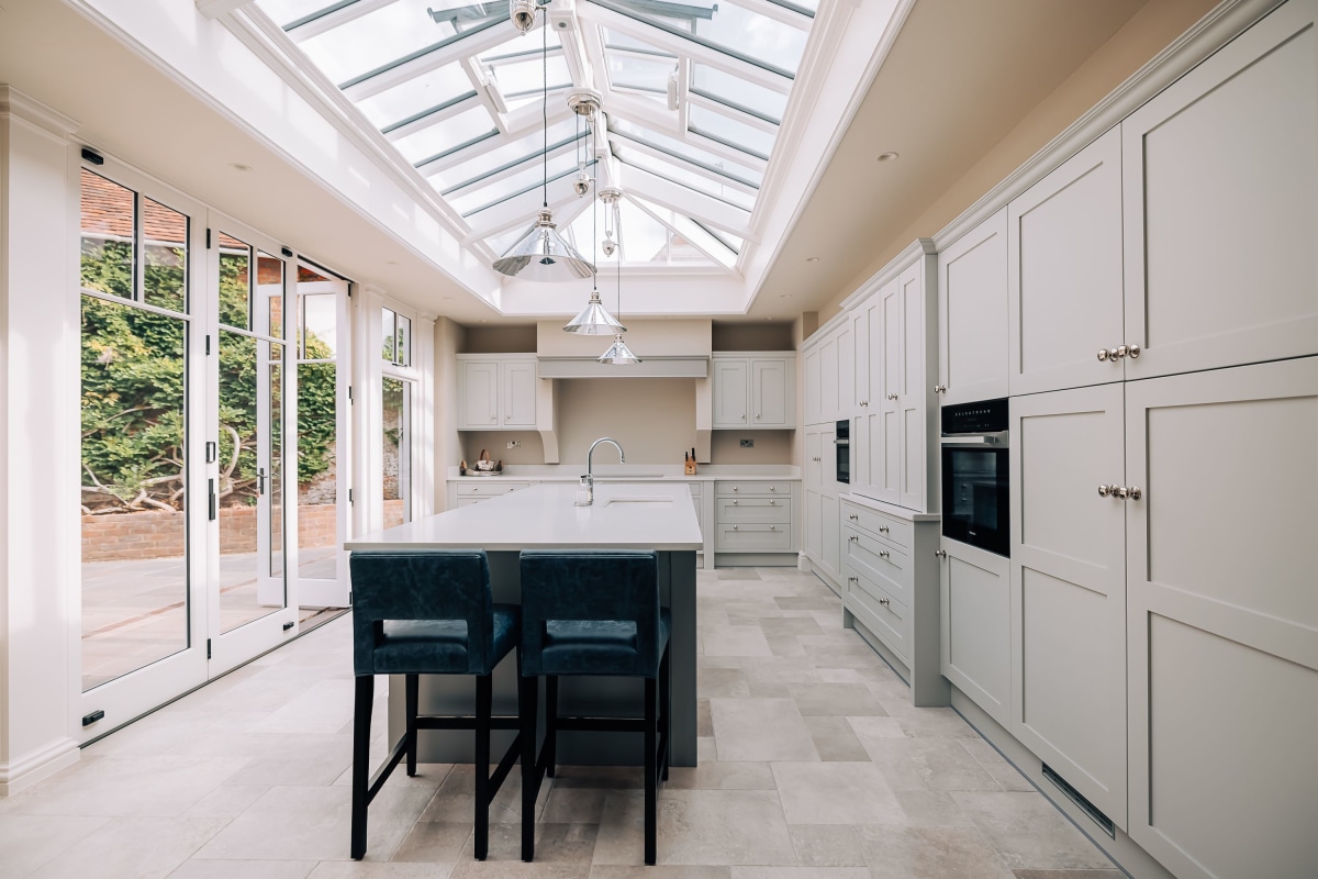 A Shaker Kitchen with a large glass lantern ceiling and glass doors to the garden