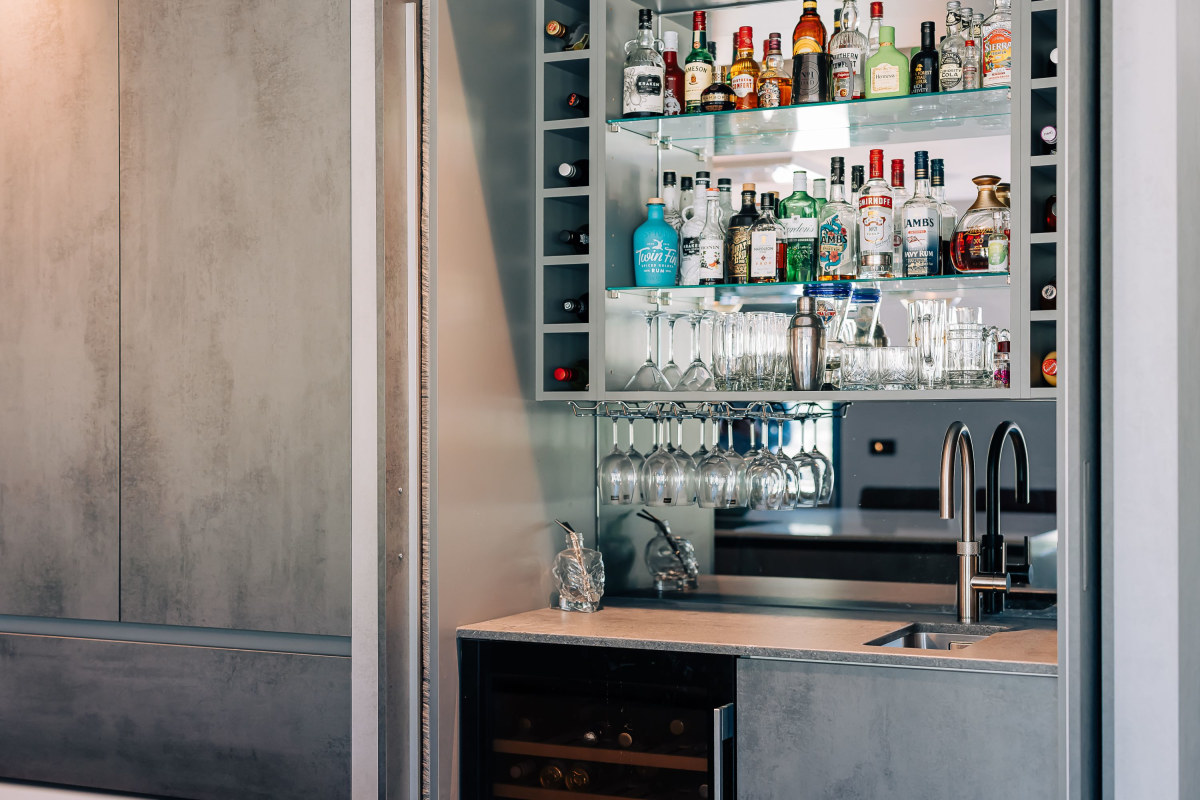 A pocket door bar stocked with an array of spirits and glassware